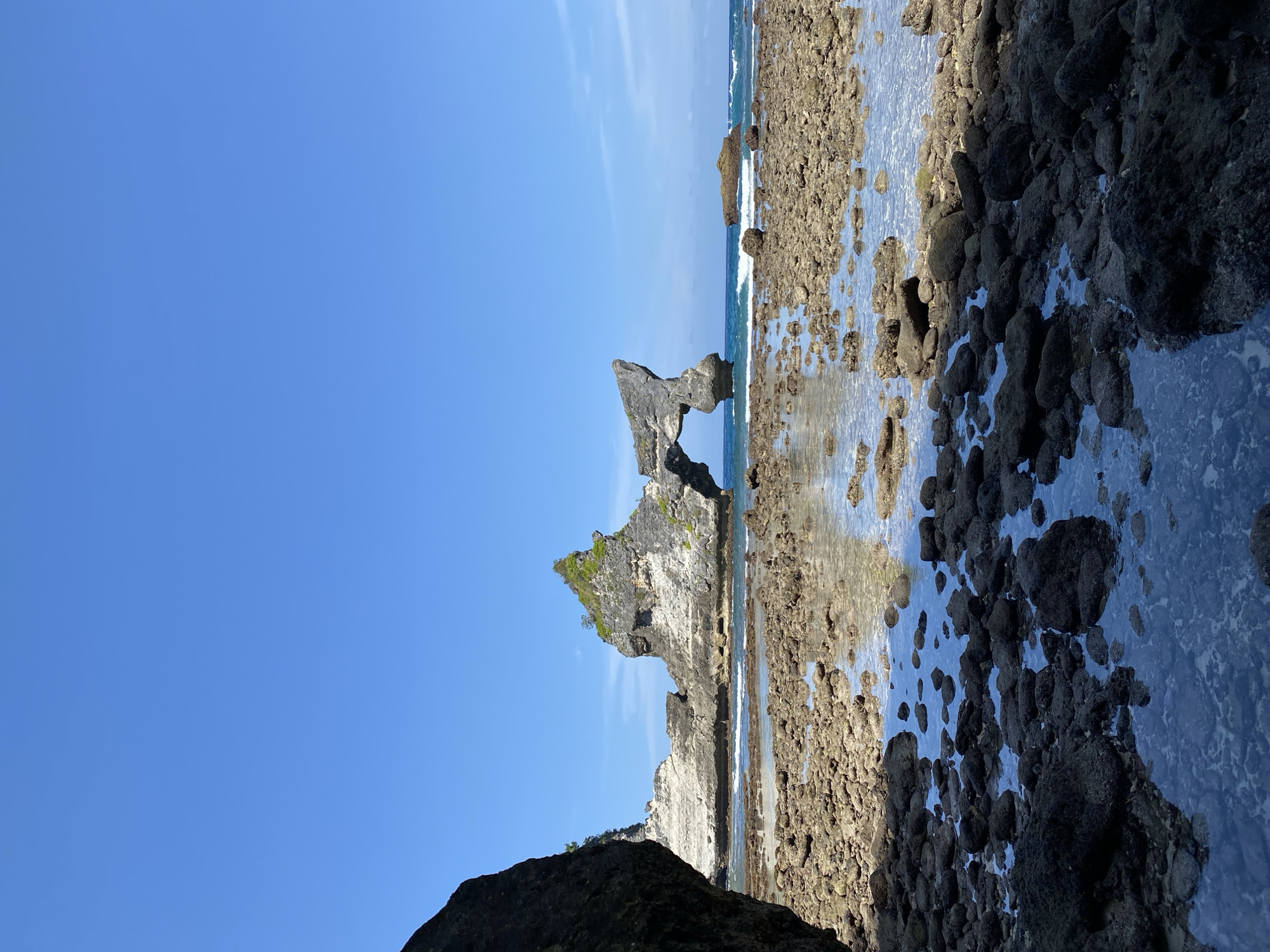 Nusa Penida's rock arch coastline and tide pools.