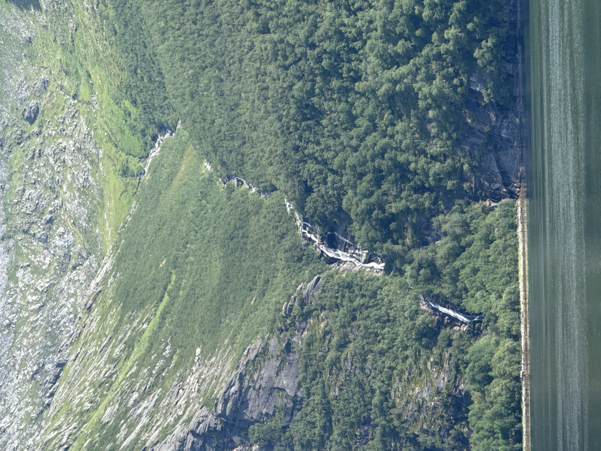 Calm fjord waters and rugged mountain slopes near Inndyr, Norway