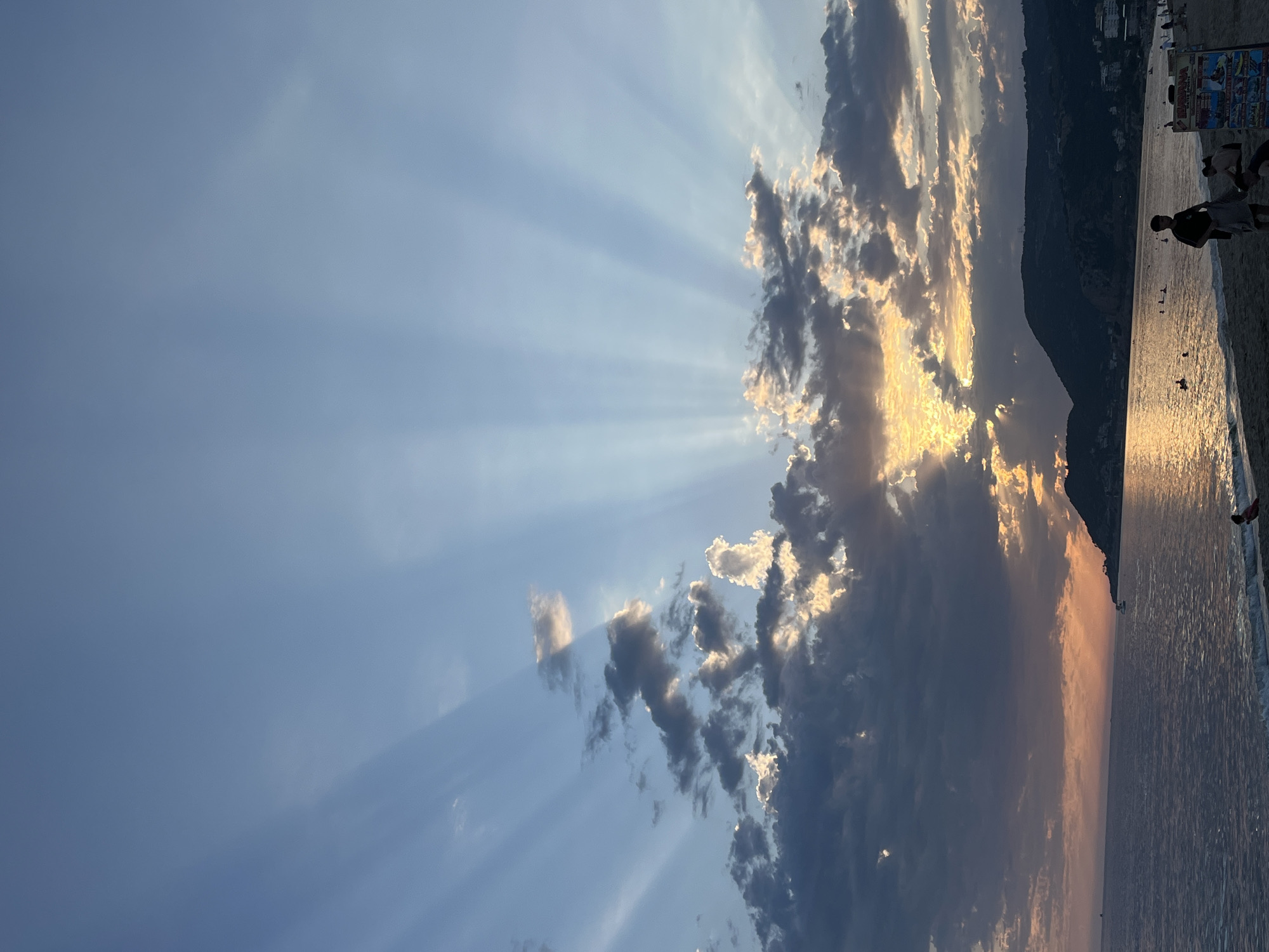 Evening beach activities observed during dramatic sunset in Alanya