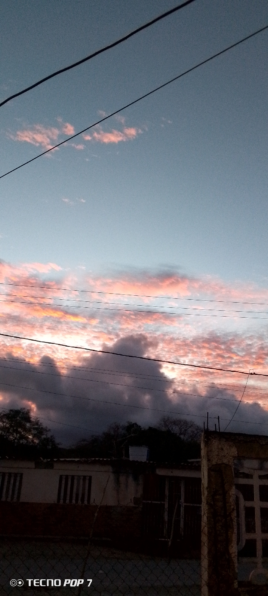 Twilight sky over Altagracia, framed by wires and trees