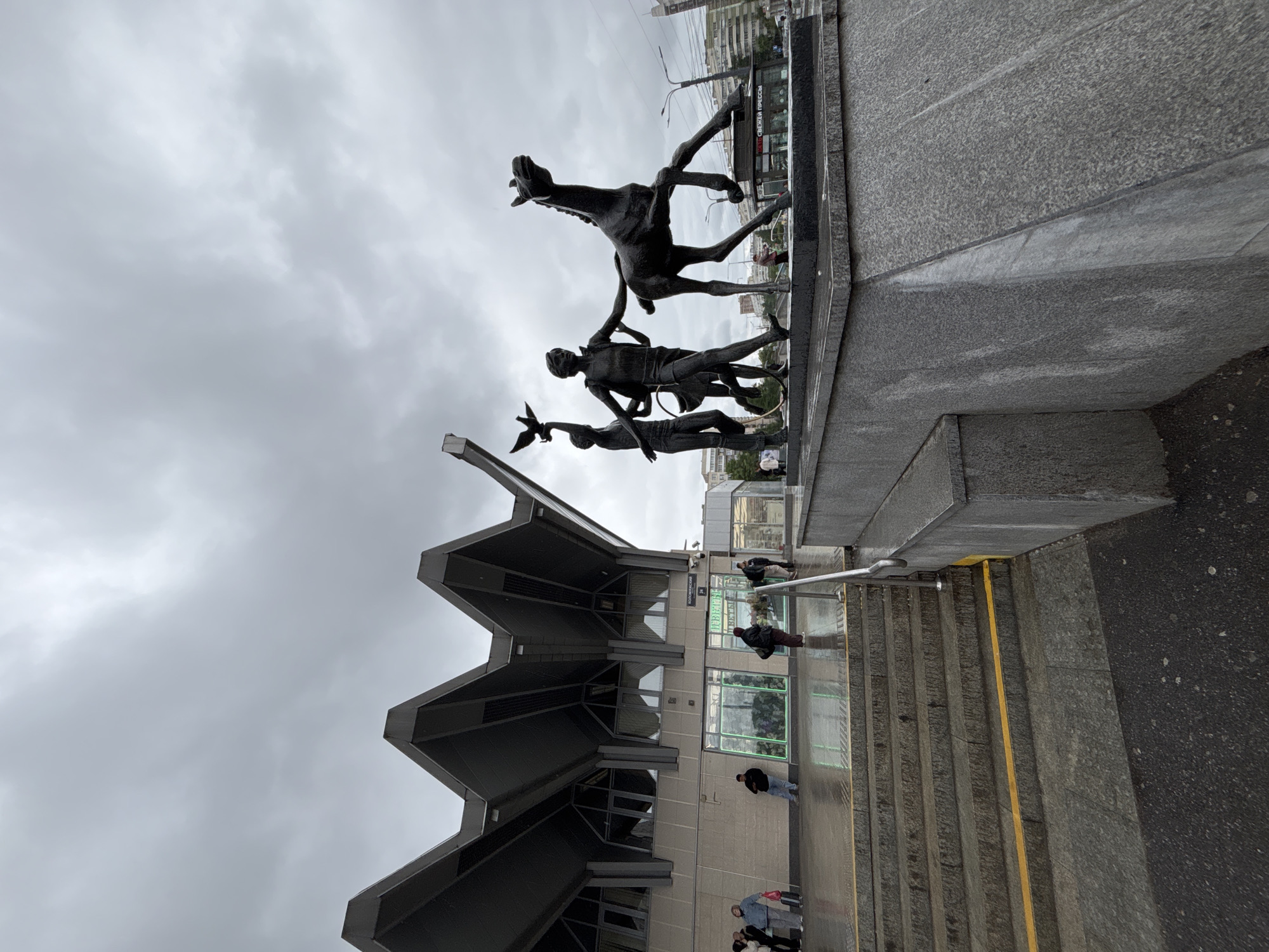Rainy morning pedestrian activity near St. Petersburg monument