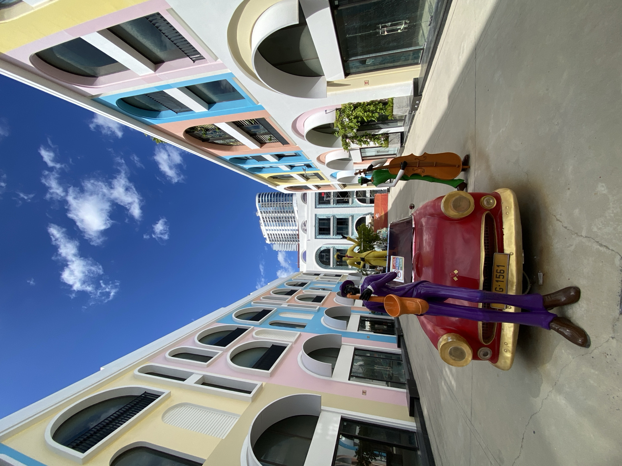 Vintage red convertible and musician statues on Nha Trang street