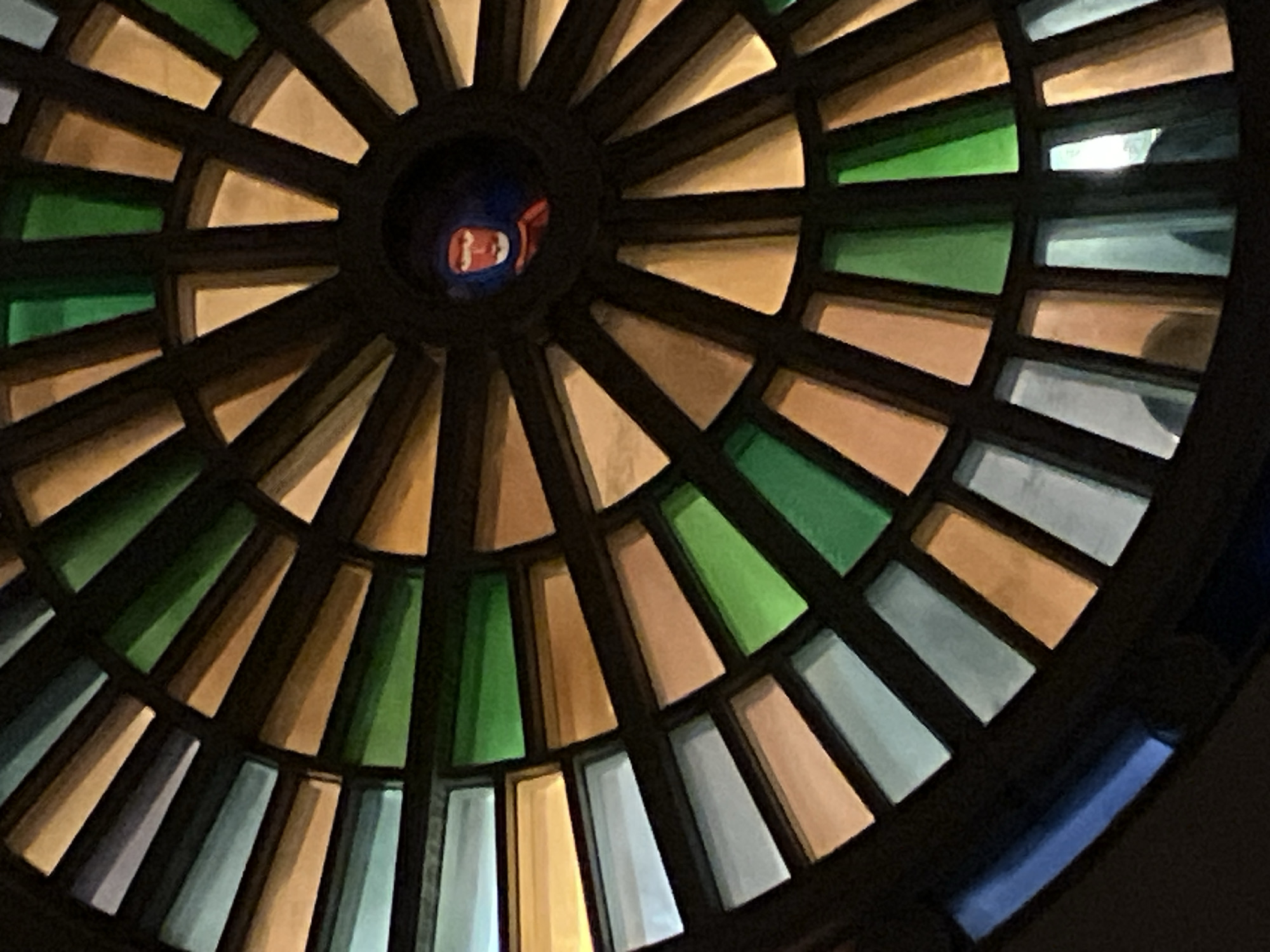 Architectural photography captures stained glass ceiling and ornate balcony