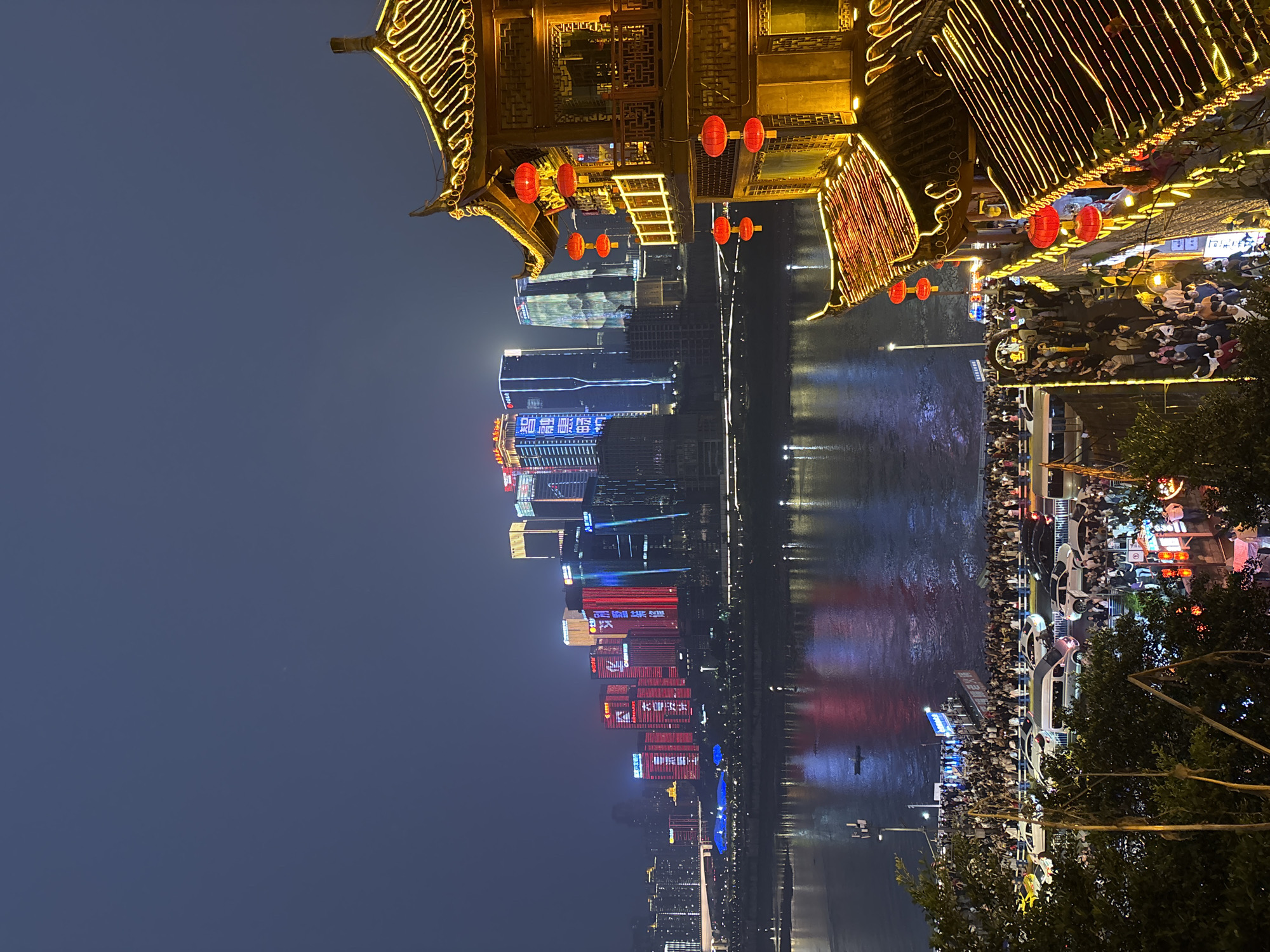 Traditional performance captured amid Chongqing's illuminated riverfront skyline