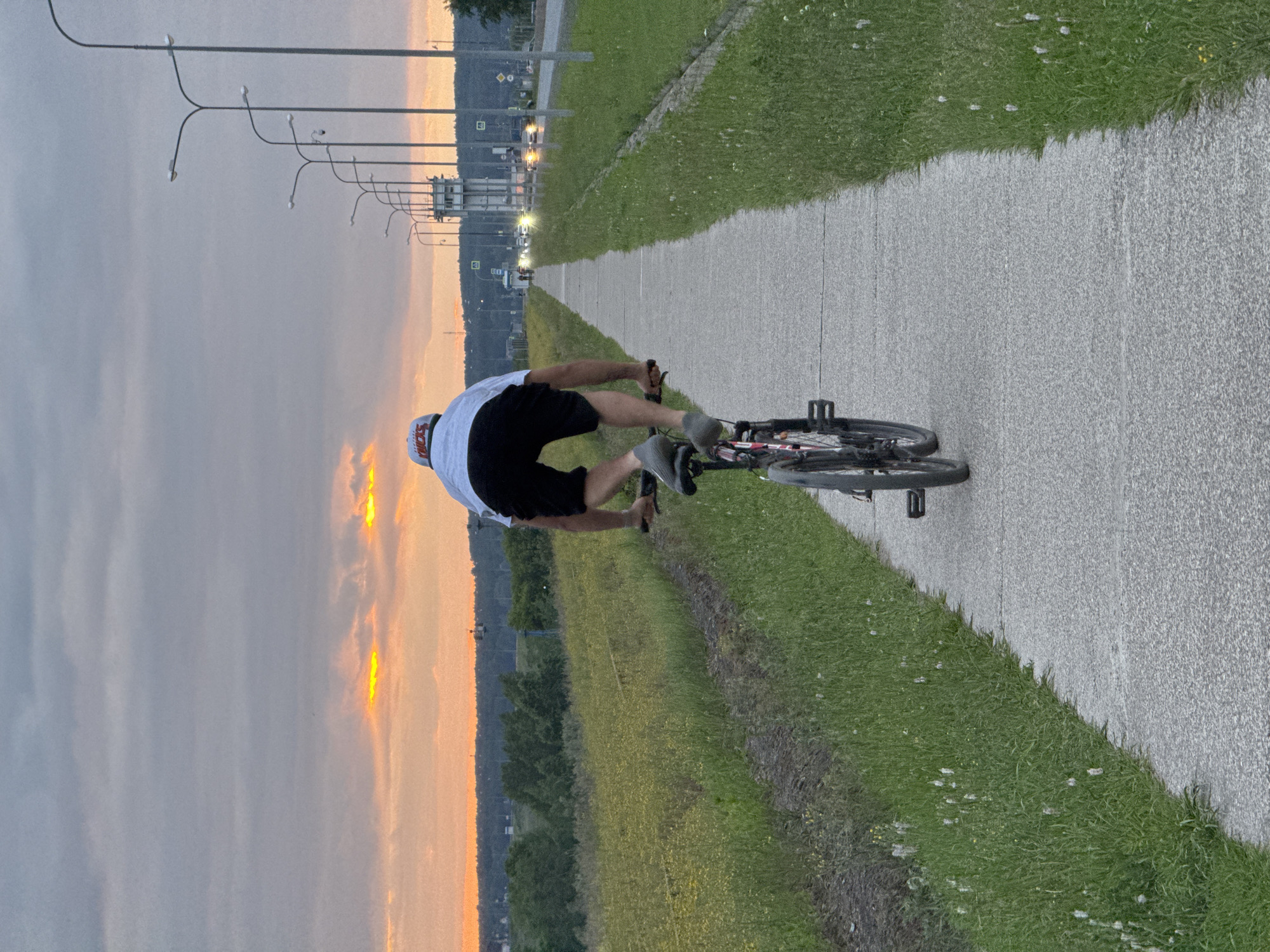 Cyclist performs stunts on path near railroad tracks in Chaikovsky