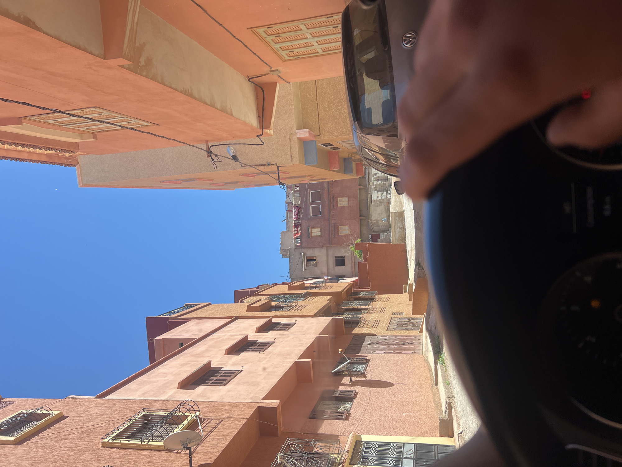Vehicle passengers document street views in Ouaouizert, Morocco