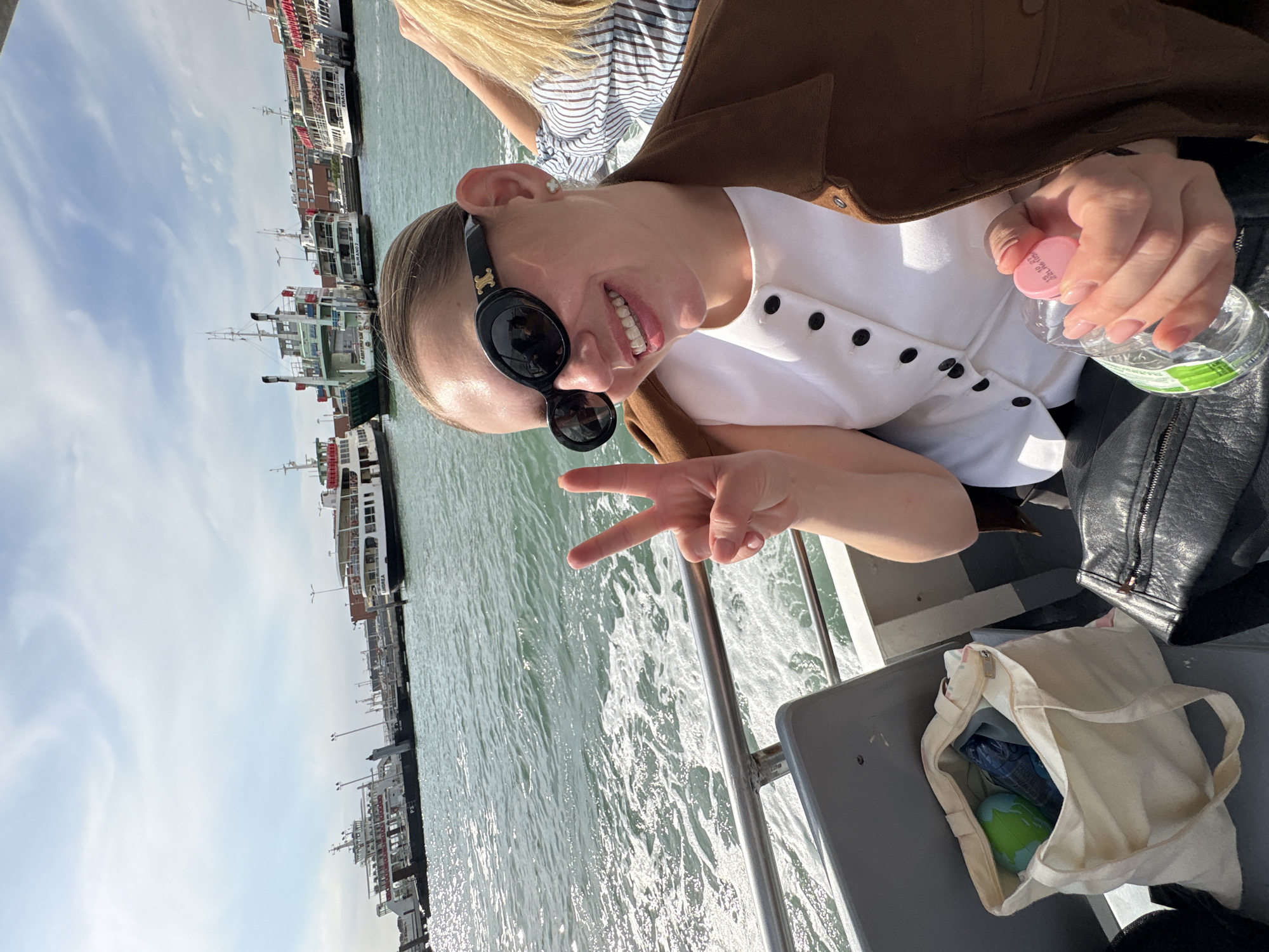 Tourists cruise Venice waterways, woman poses with peace sign