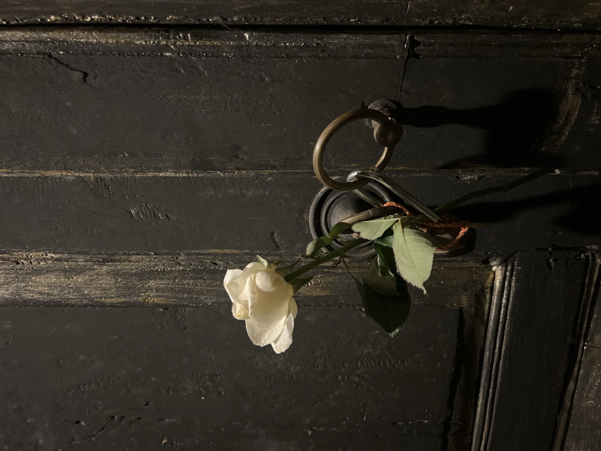 Floral offerings left at door and stone carving in Sukawati