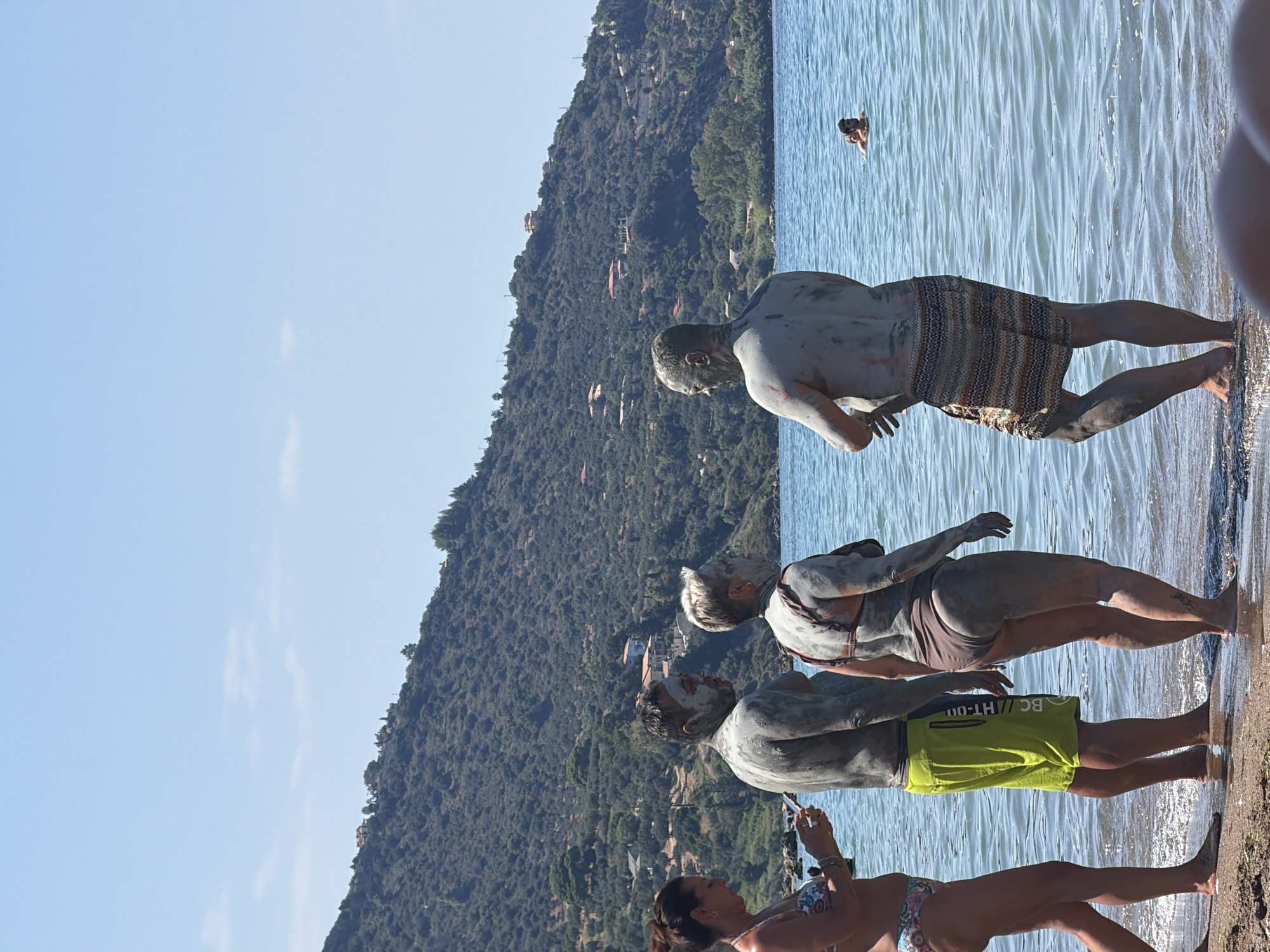 Mud-covered beach day among rocky coastal formations