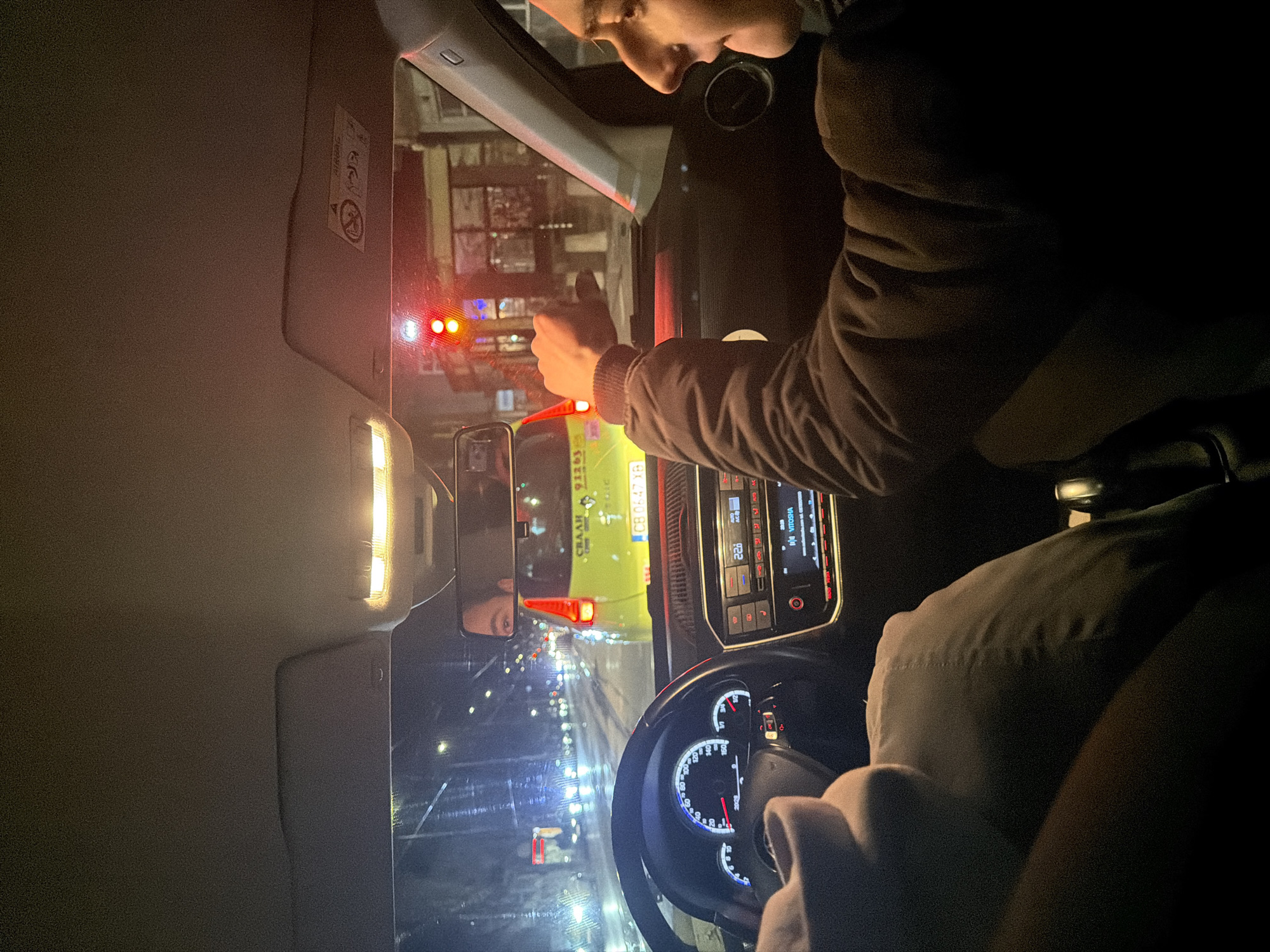 Driver gives thumbs-up during nighttime car ride in Sofia