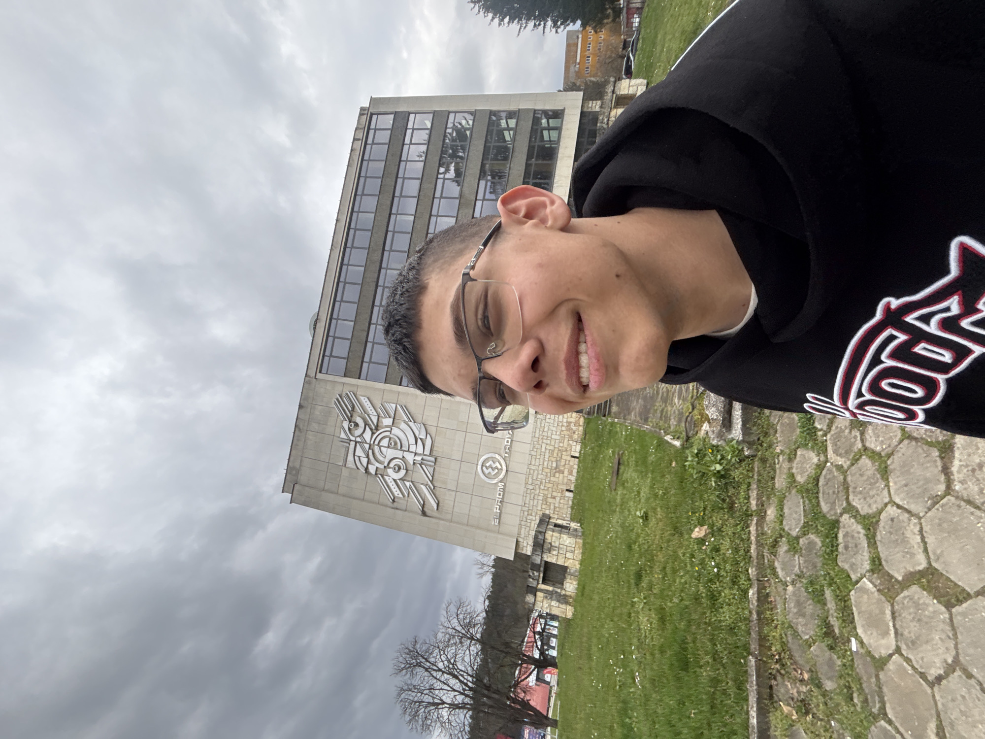 Young man takes selfies outside building in Troyan, Bulgaria