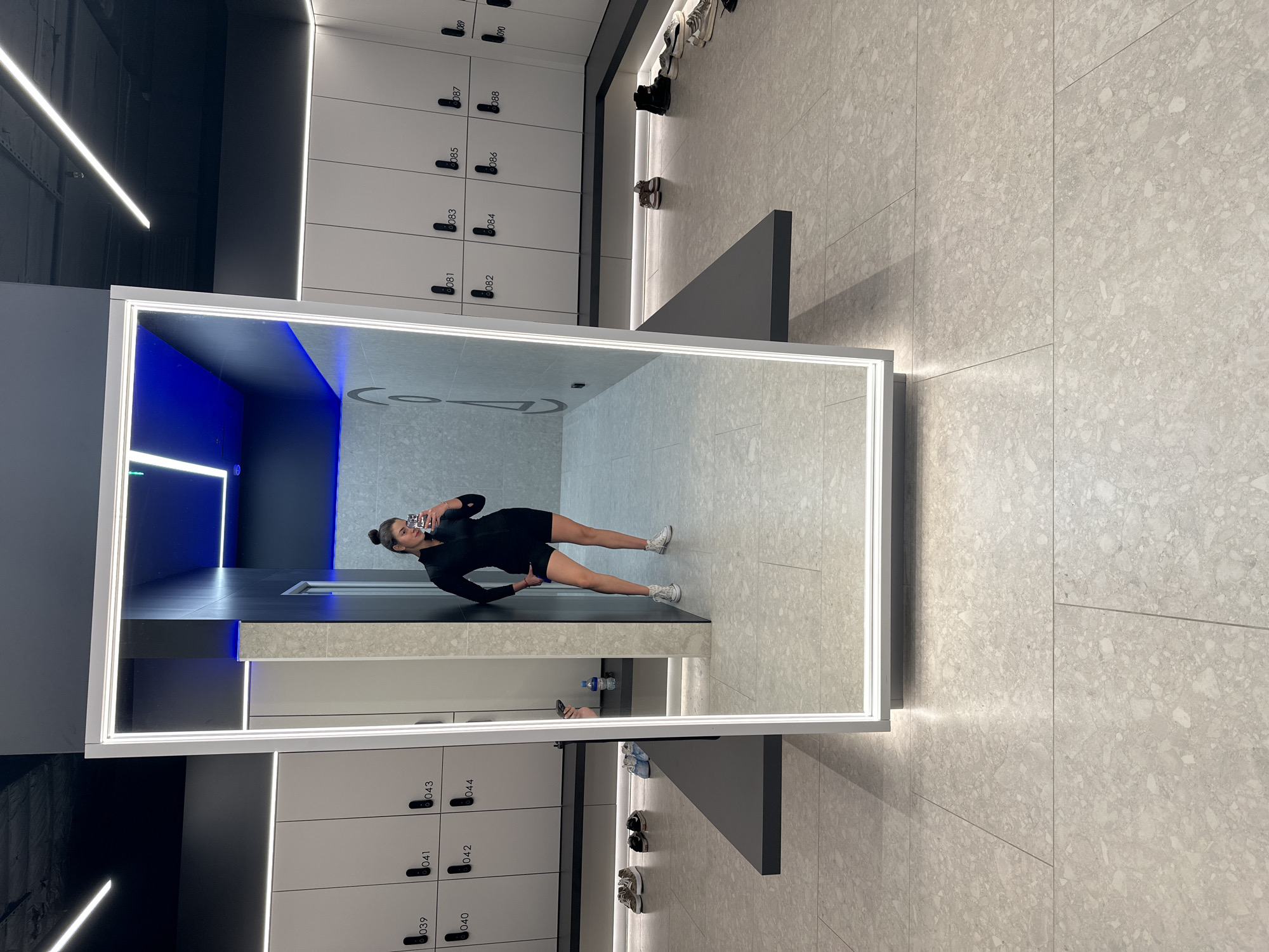 Woman takes mirror selfie in Russian gym locker room