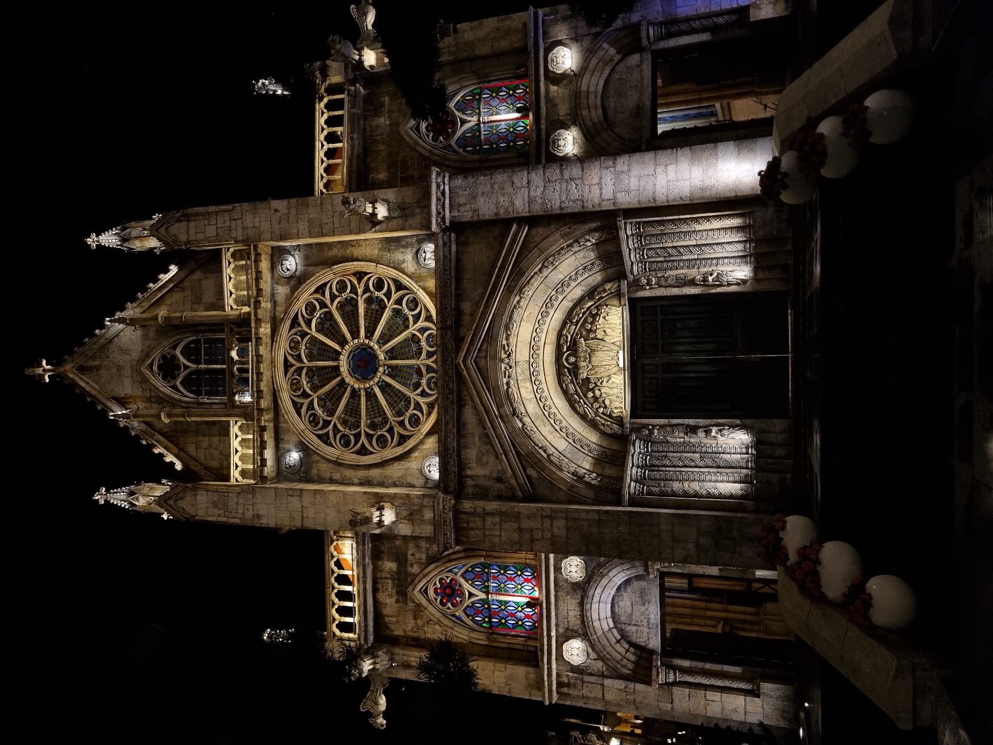 Gothic stone church facade lit up at night
