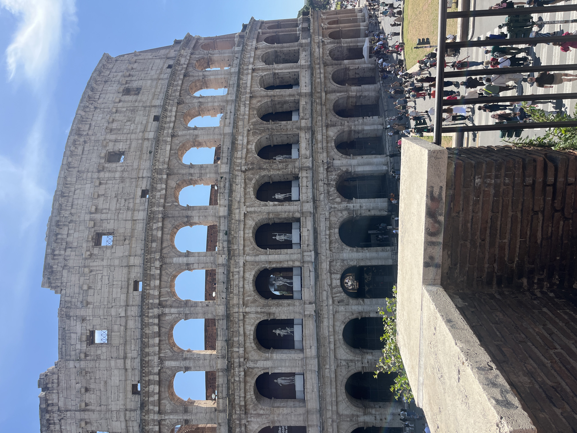 Tourist photographs document Colosseum under clear Rome skies