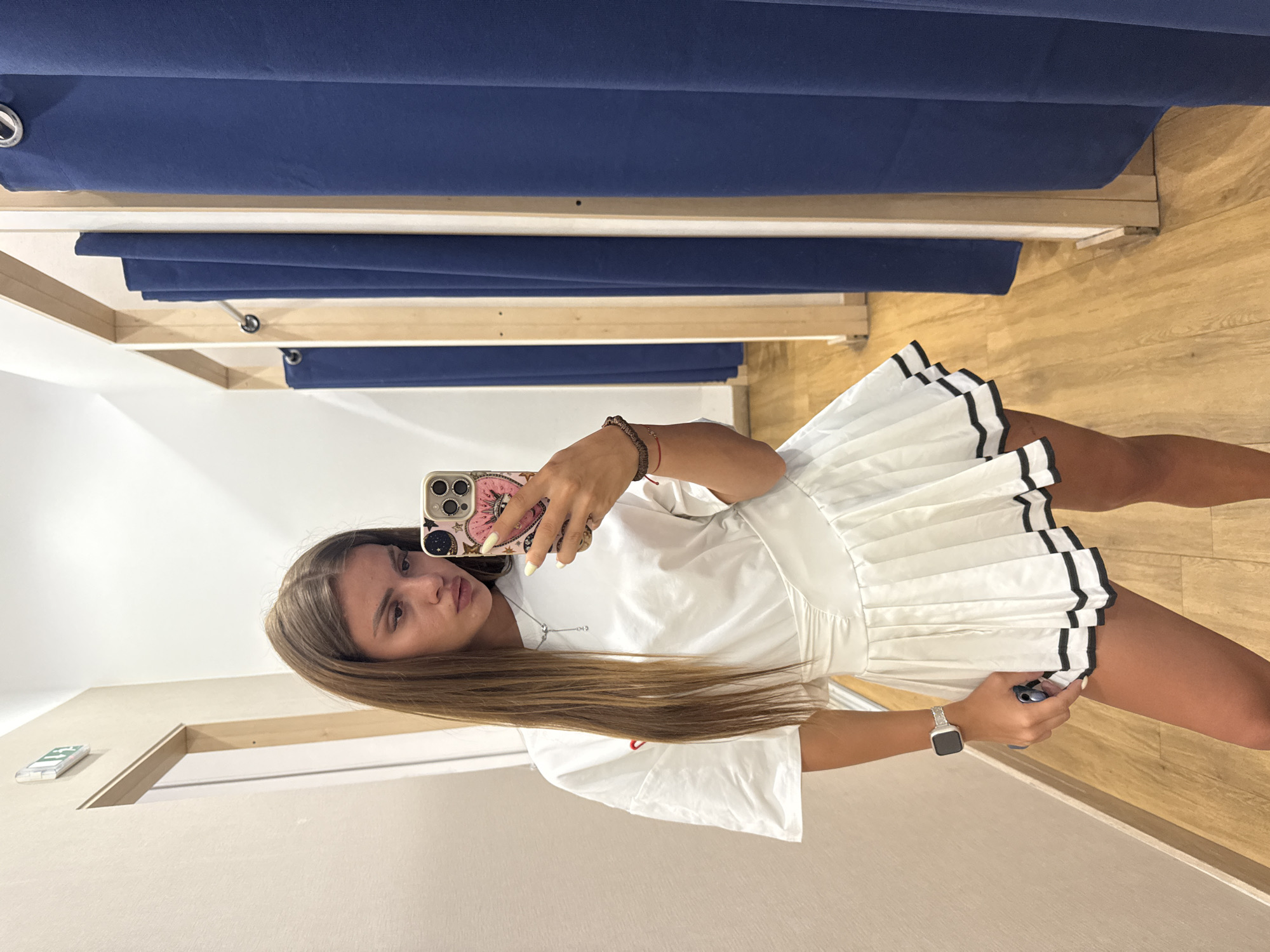 Fitting room mirror selfies in a white pleated skirt outfit