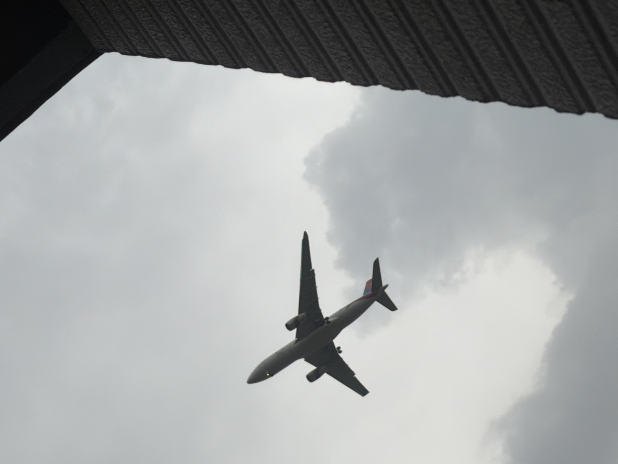 Planes over Delhi and a rainy rooftop view of Qutub Minar