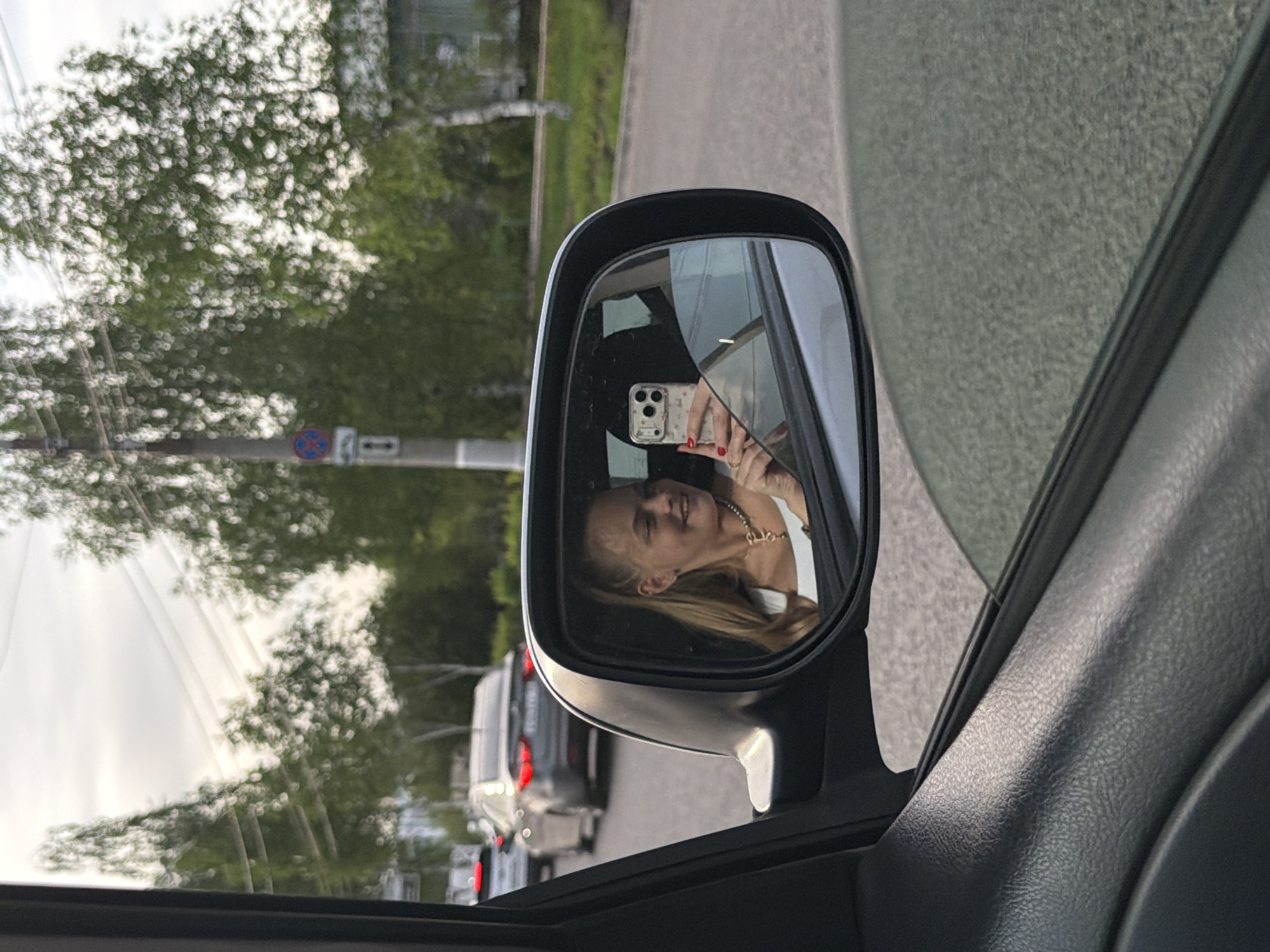 Woman takes car mirror selfies in Izhevsk