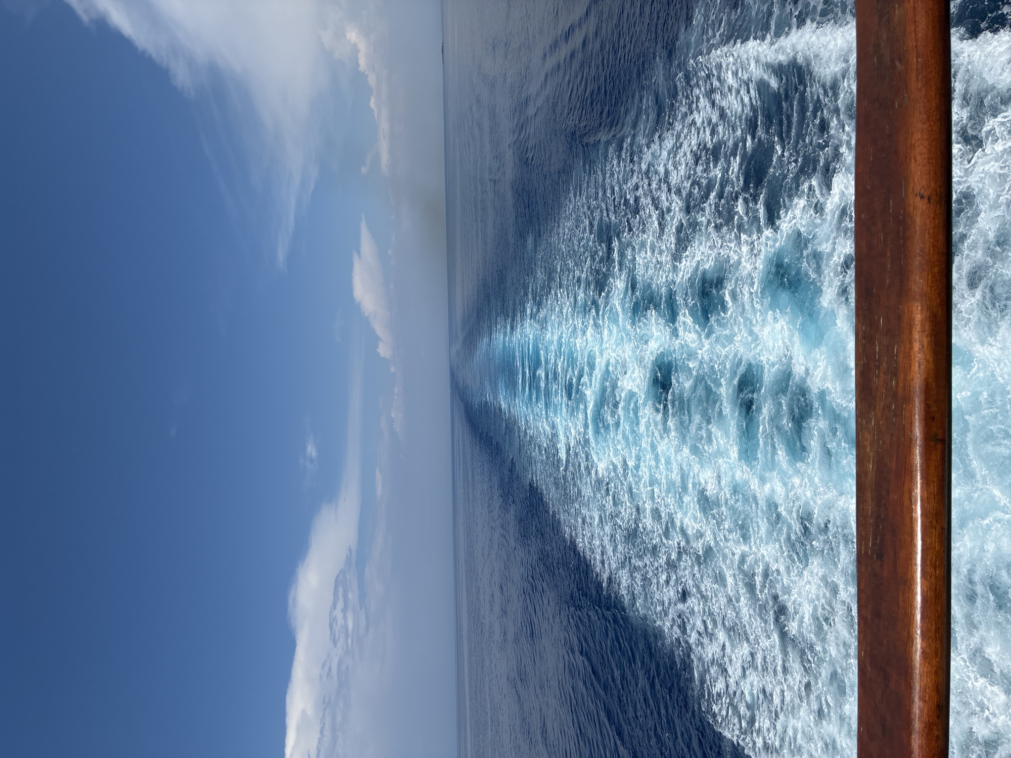 Boat wake cutting through blue Ionian water near Kafkalida
