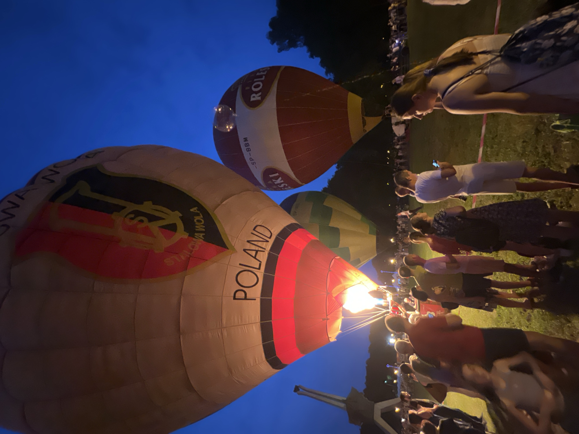 Hot air balloons glow at dusk over Tychy festival grounds