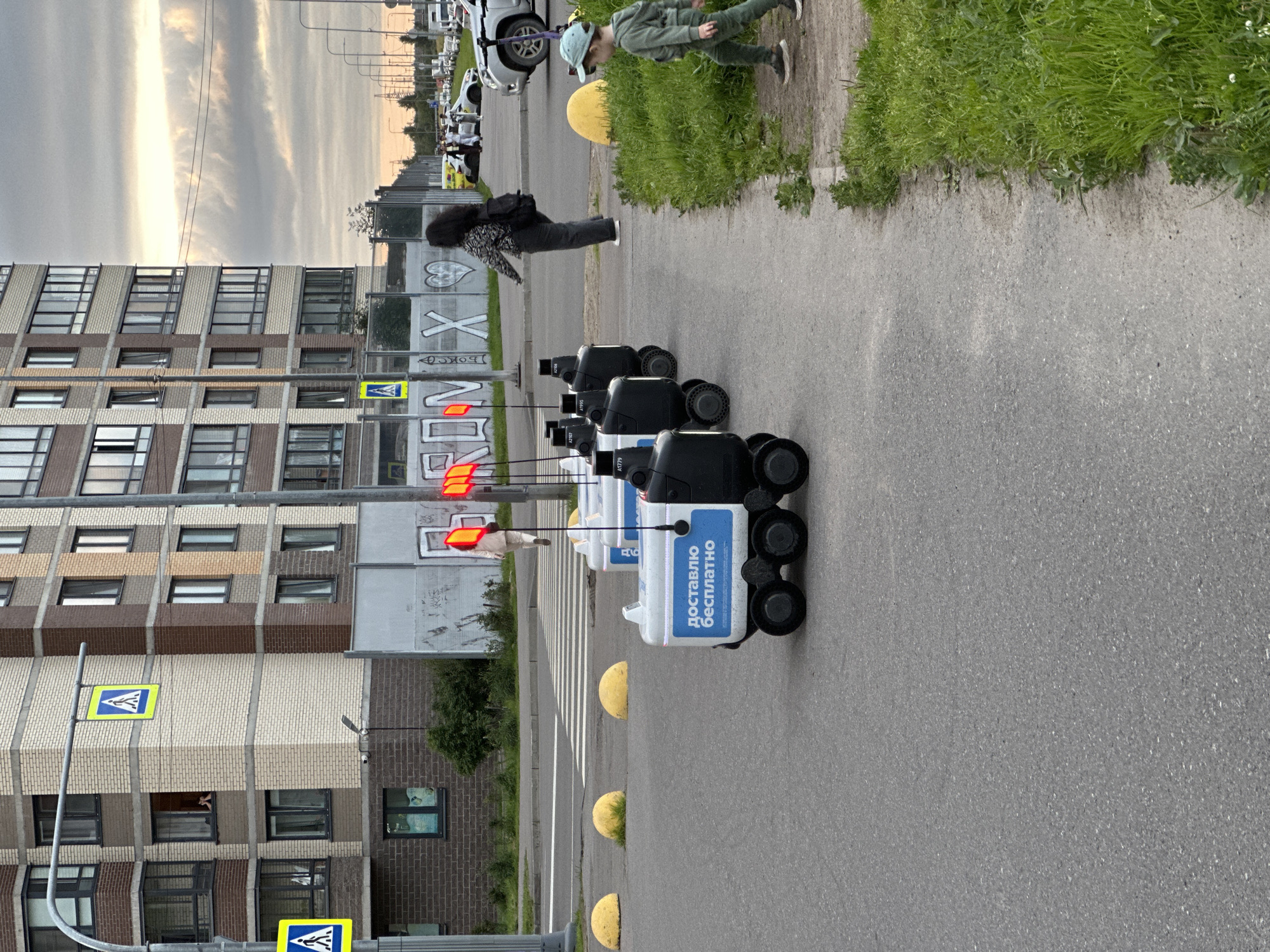 Autonomous delivery robots lined up outside a Sinyavino apartment block