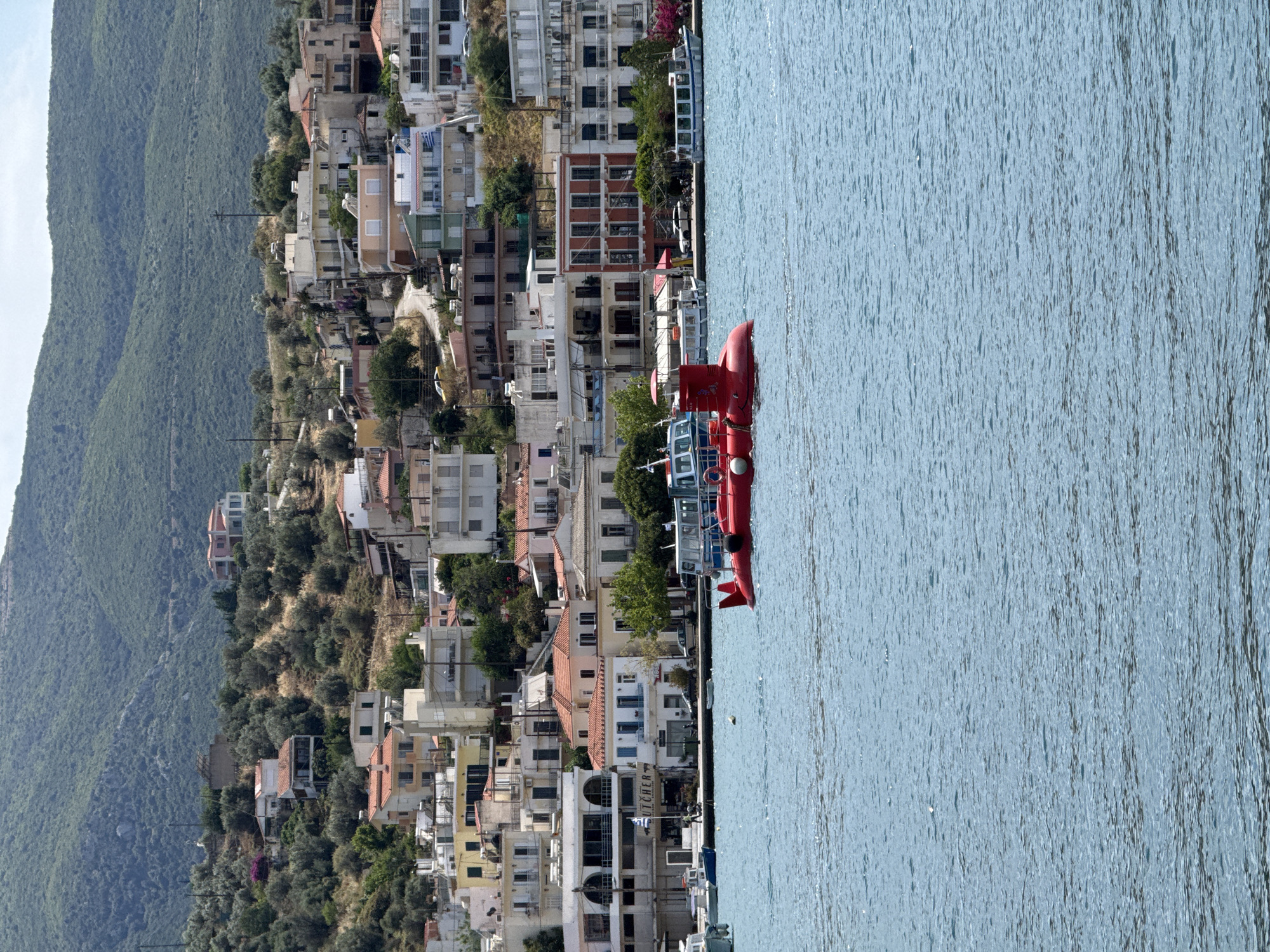 Tourists and locals enjoy typical morning activities in Poros, Greece