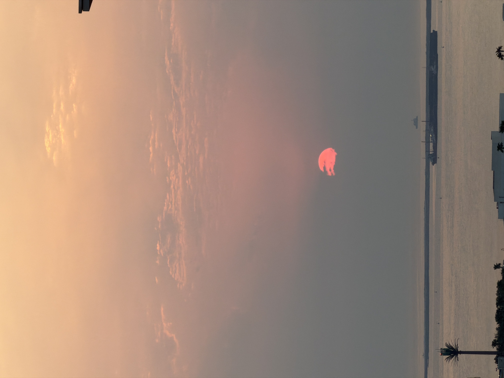 Sunset over Lusail's waterfront, sky glowing orange and pink