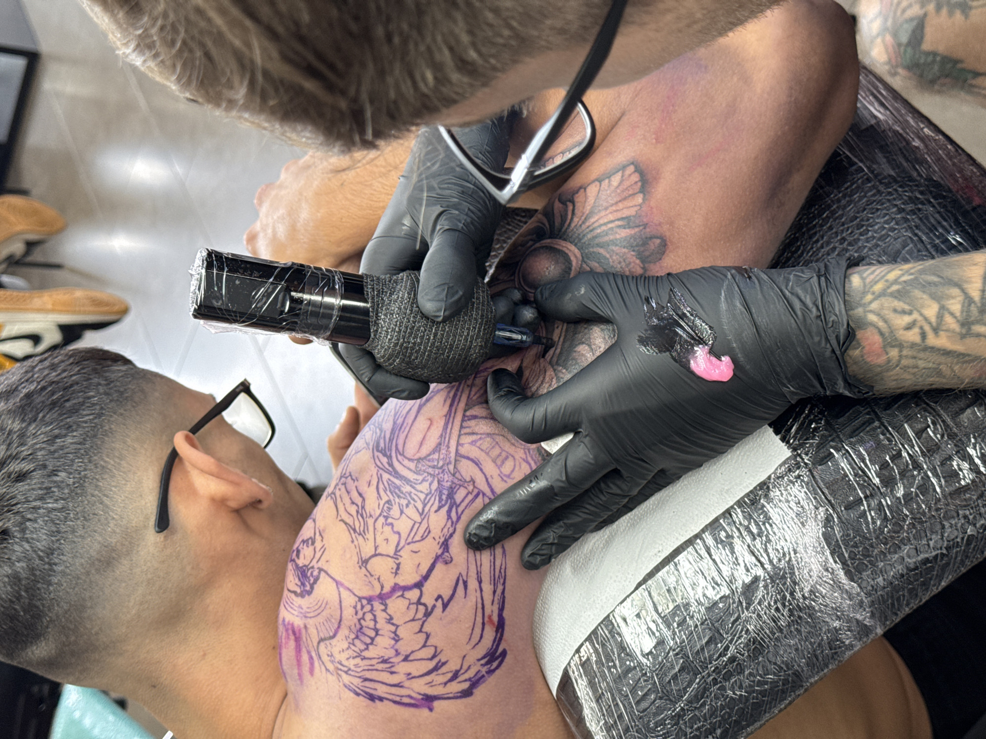 Tattoo artist applies koi fish design in Yaiza studio