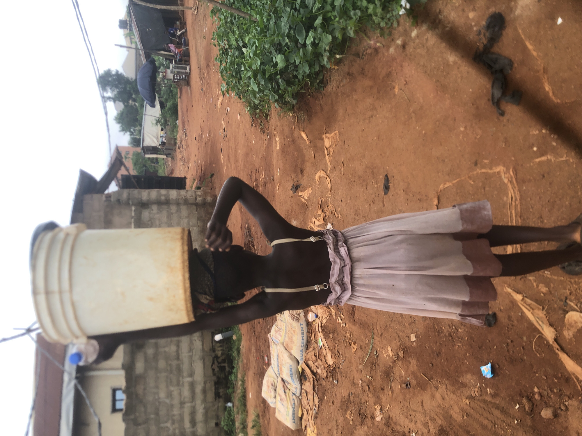 Girl carries water bucket in Ukwu-Abwa, Nigeria
