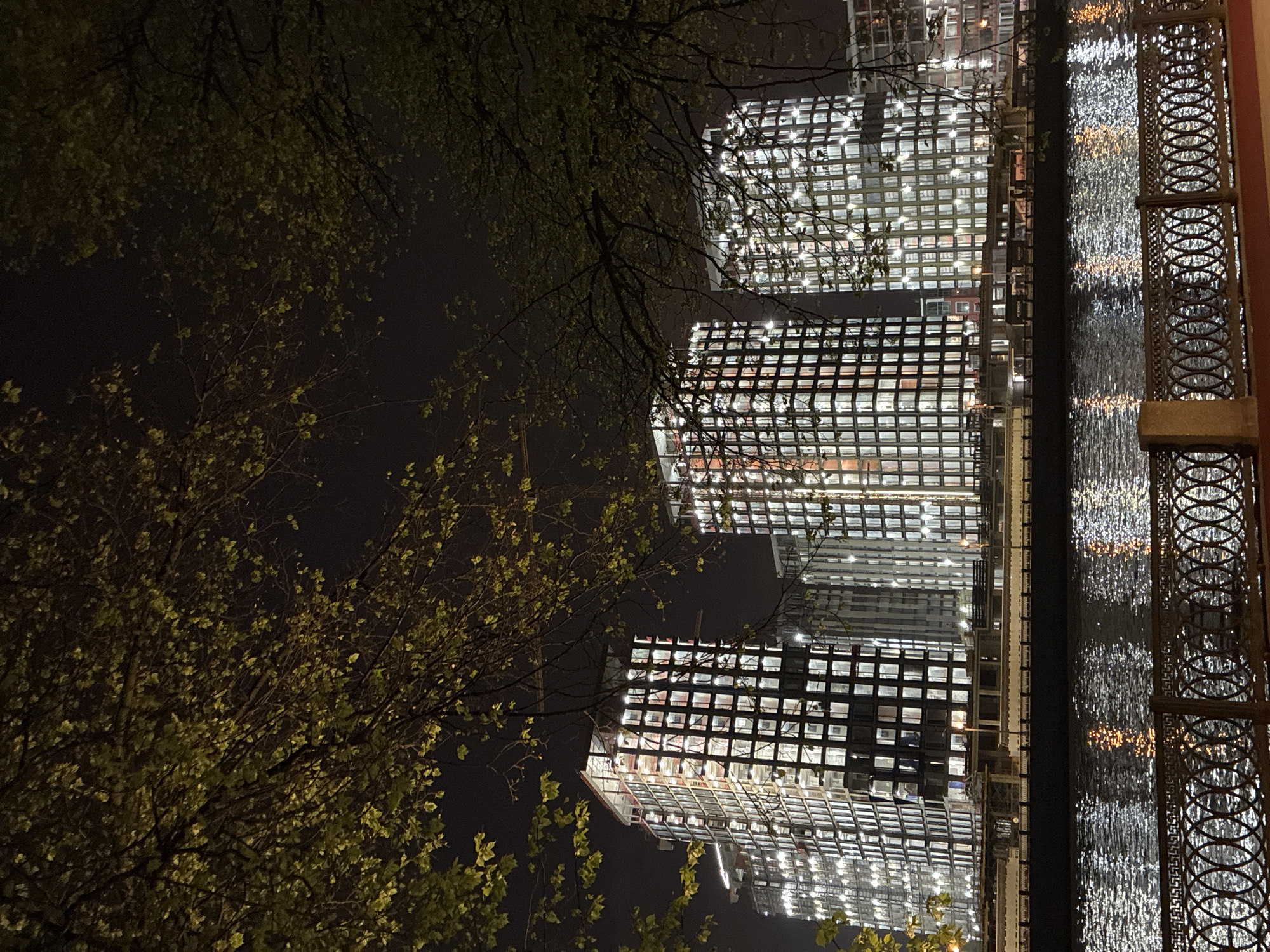 Illuminated Moscow buildings reflect in water at night