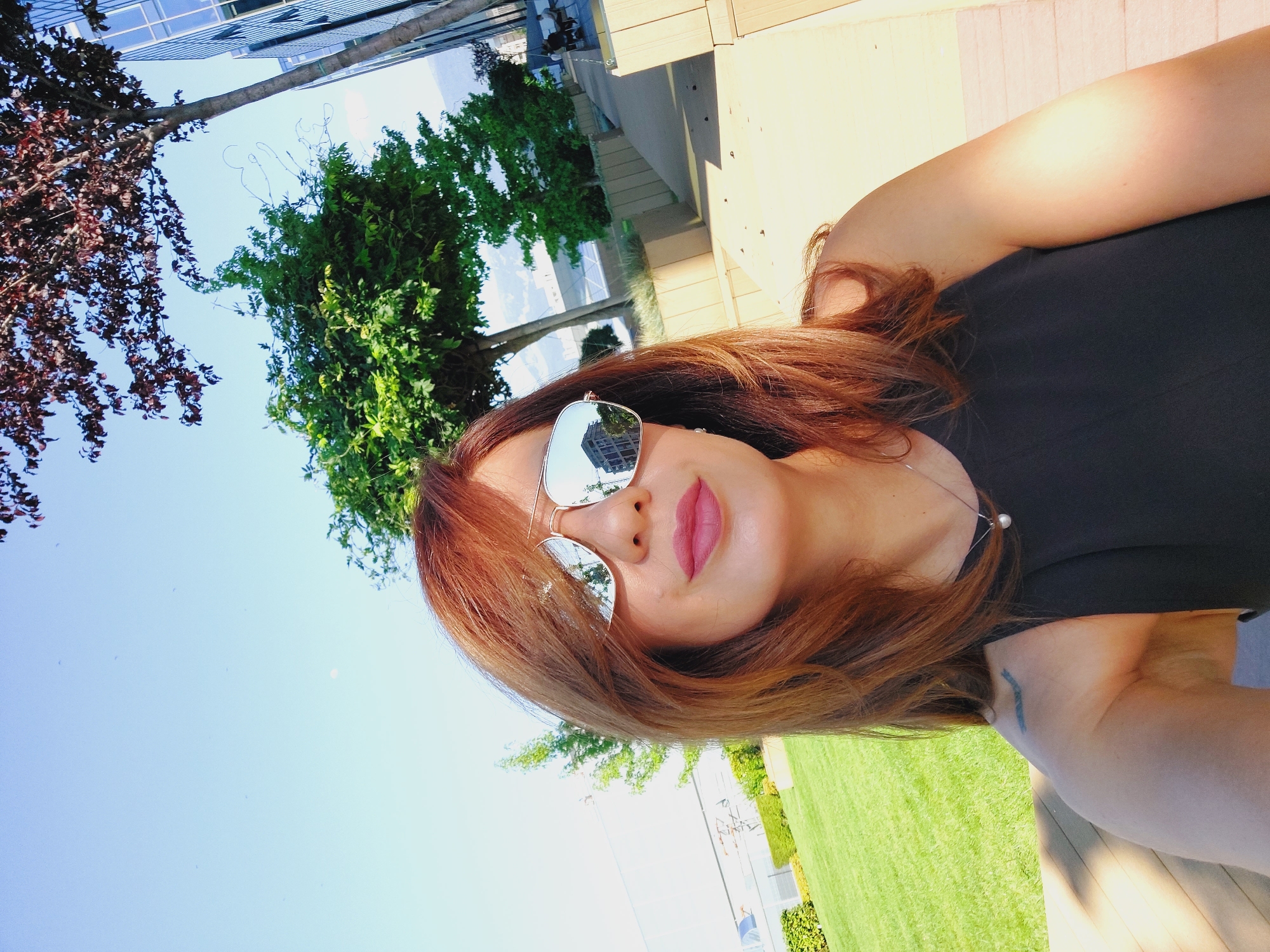 Sunny rooftop selfie session outside a modern glass building