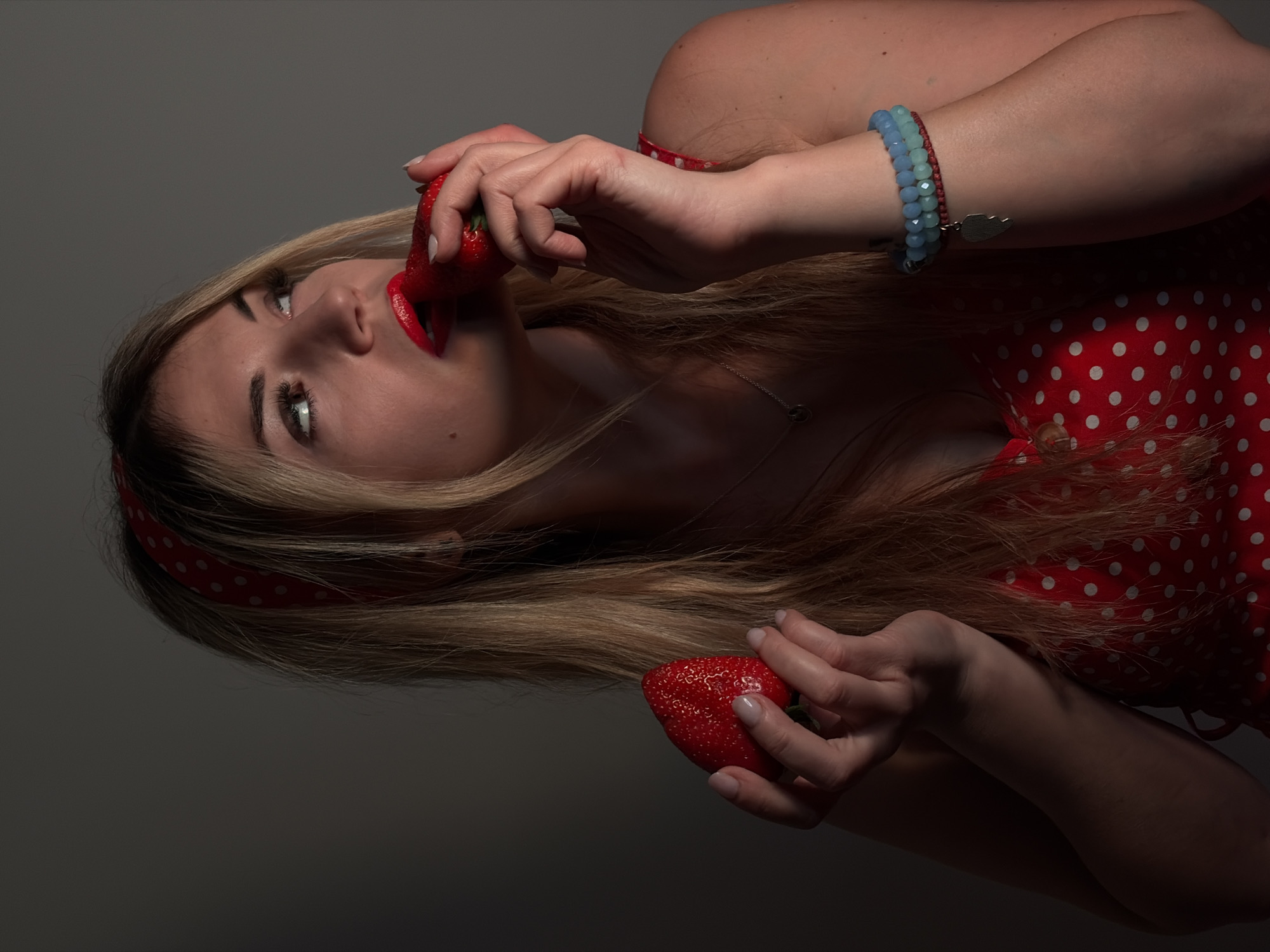 Woman in polka dot dress poses with strawberries in Budva