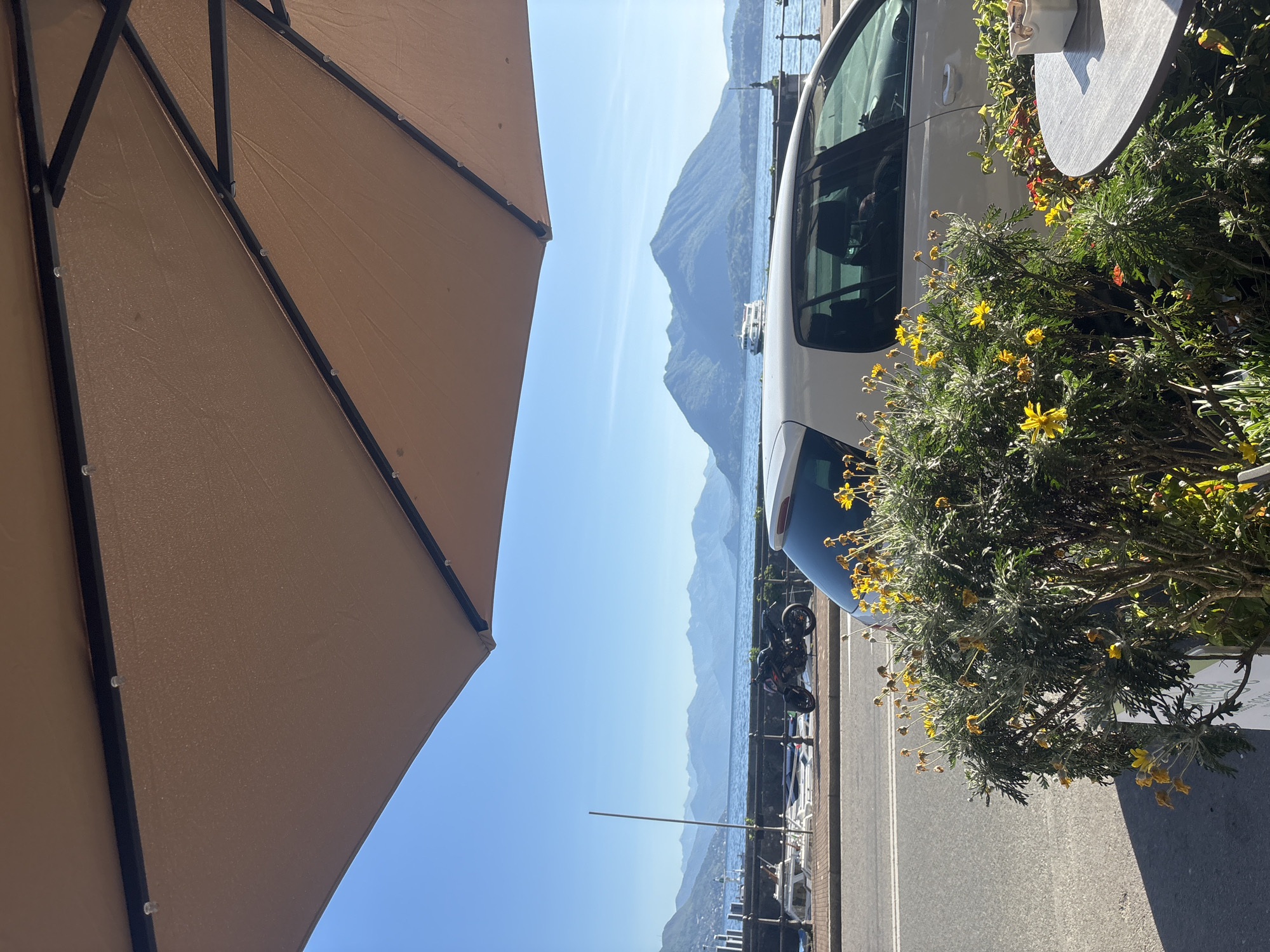 Woman enjoys breakfast at lakeside cafe in Binda, Italy