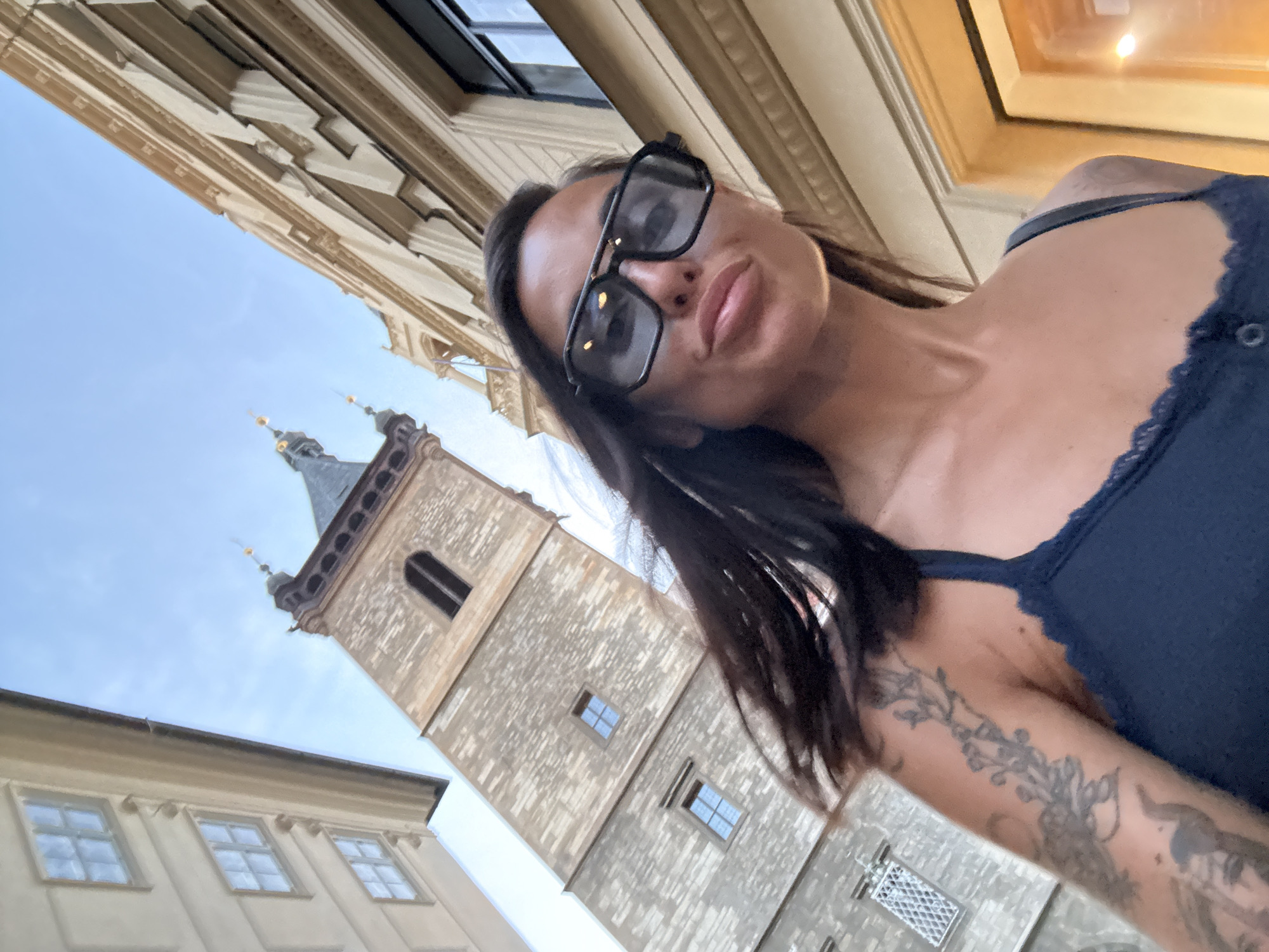 Selfie with a historic Prague tower looming behind