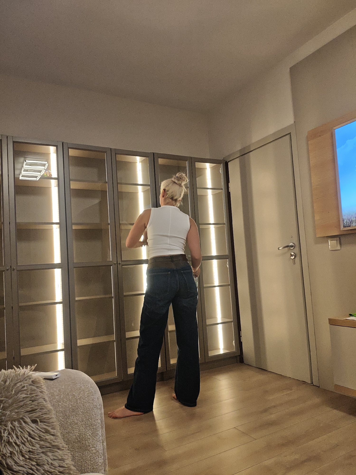 Woman examines furniture, cityscape views captured in residential setting