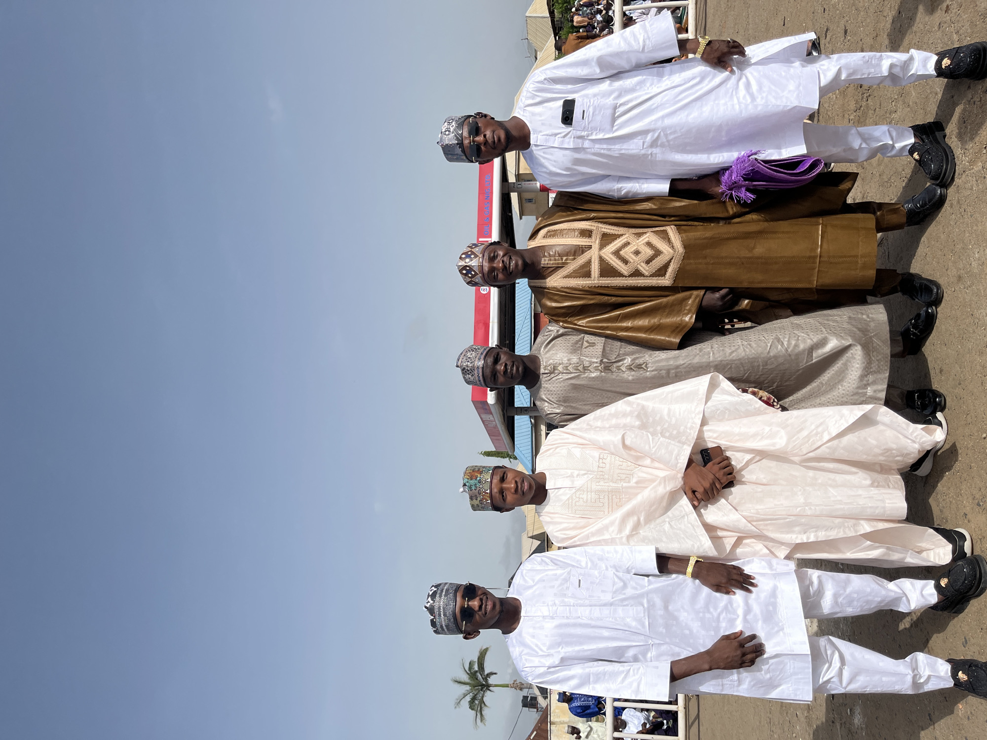 Men in traditional dress gather for photos outdoors