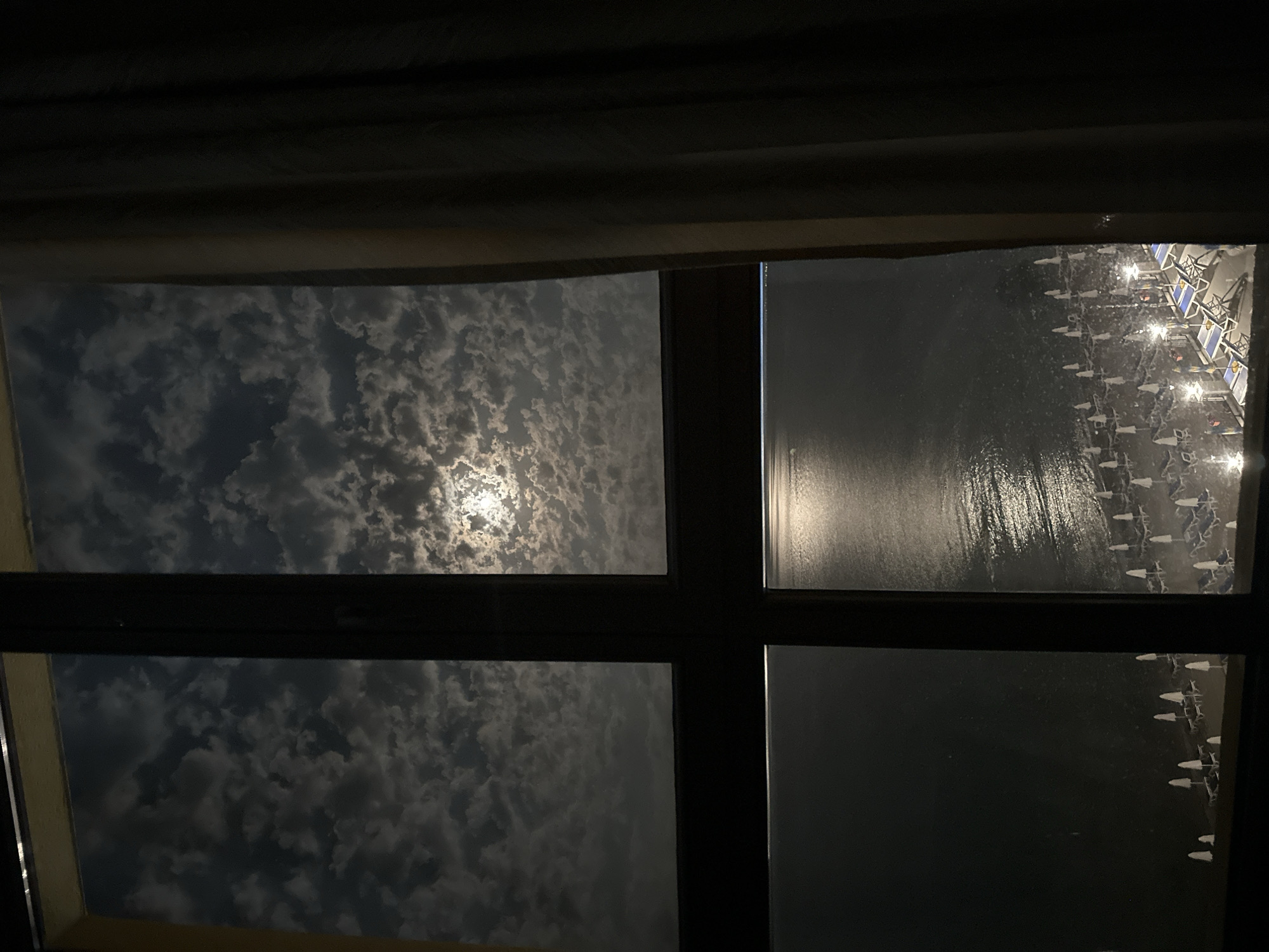 Moonlit beach view through a window in Nesebar at night