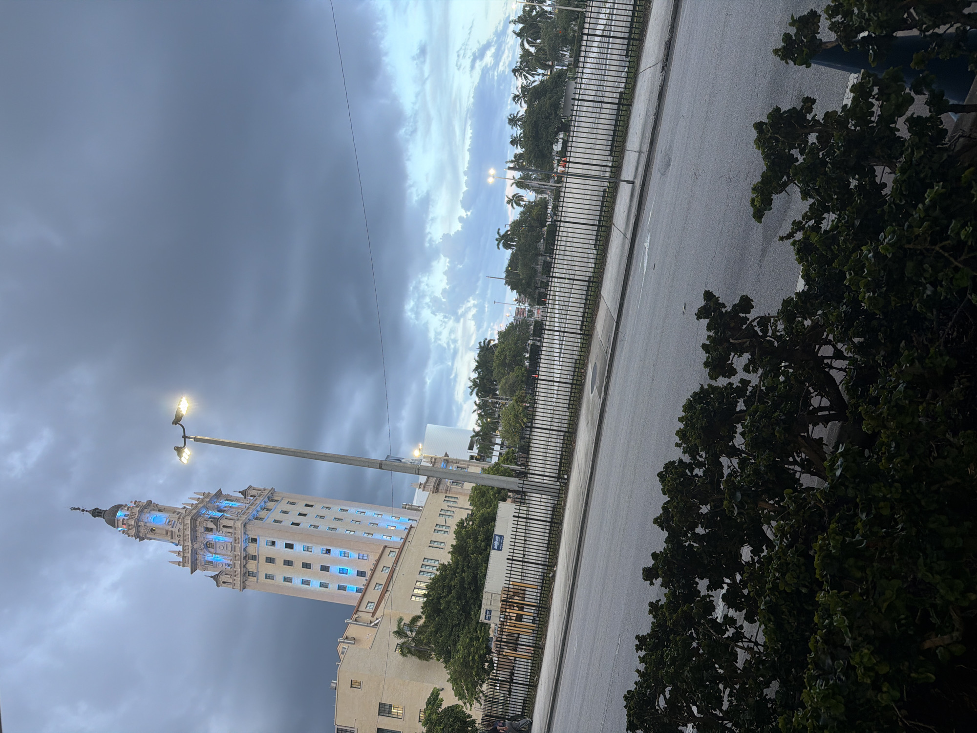 Freedom Tower lit up blue under cloudy Miami skies