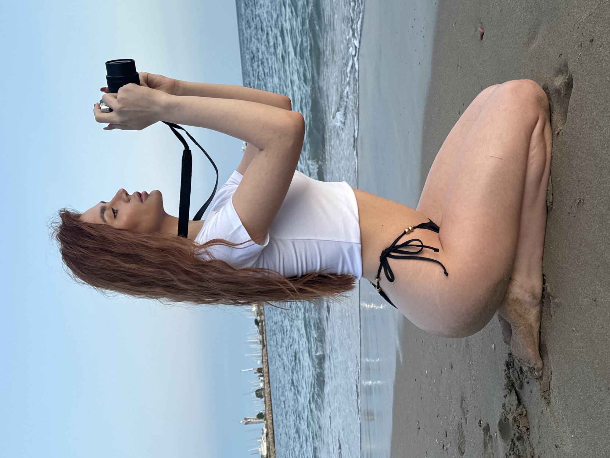 Woman photographs sunset at Greek beach in evening session