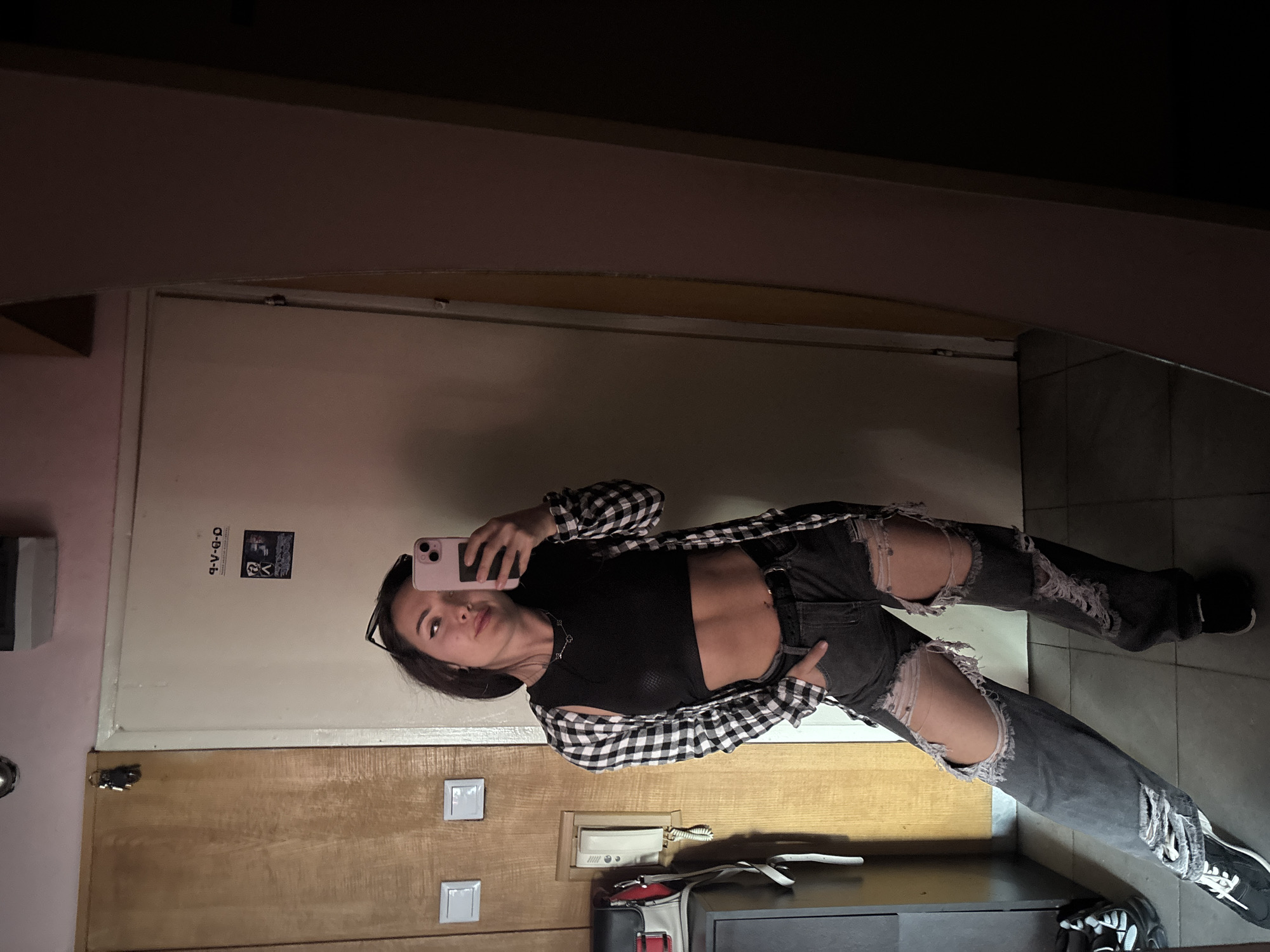 Woman takes mirror selfie in casual outfit