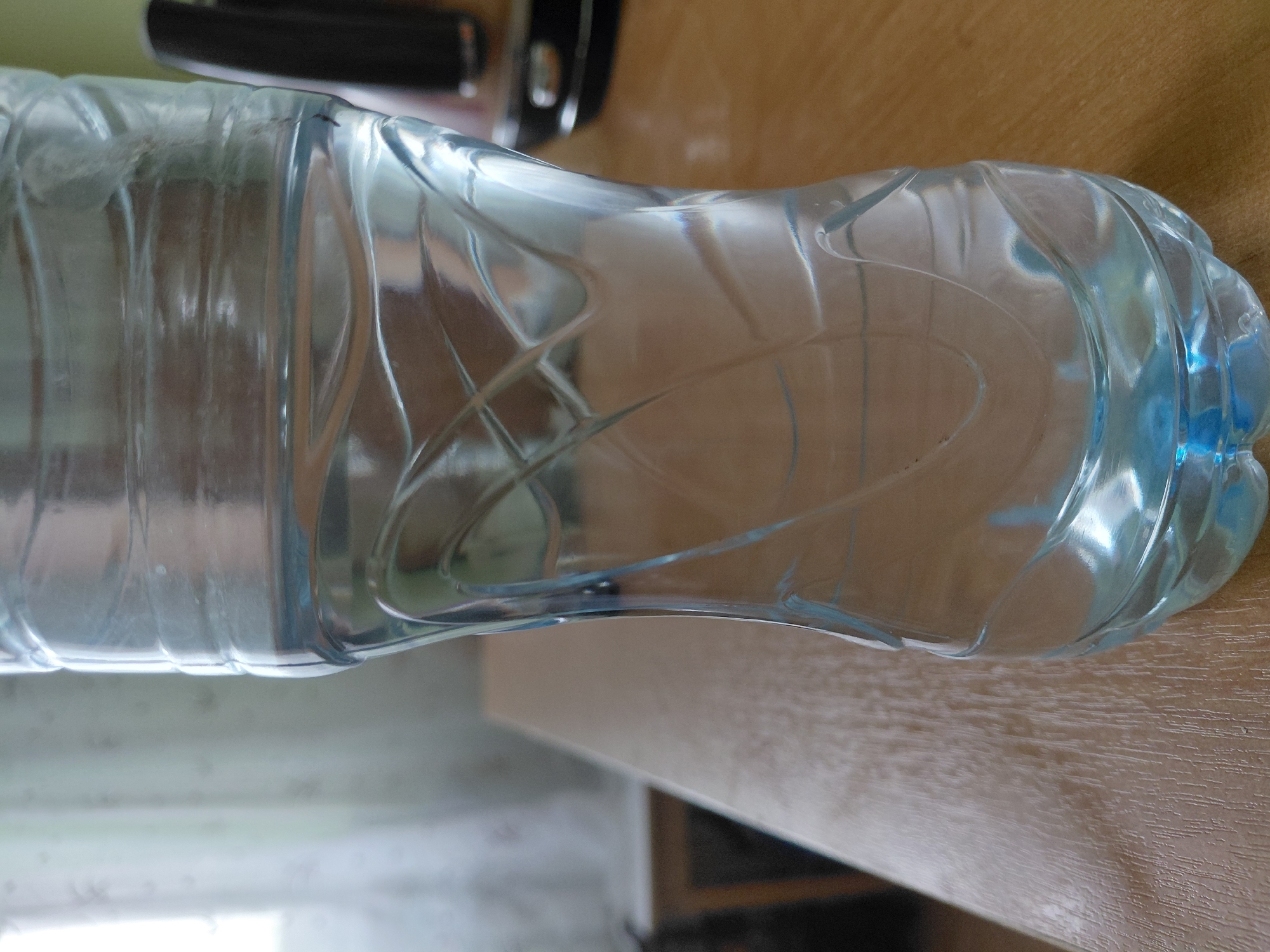 Craft materials and water bottle spotted on wooden surface
