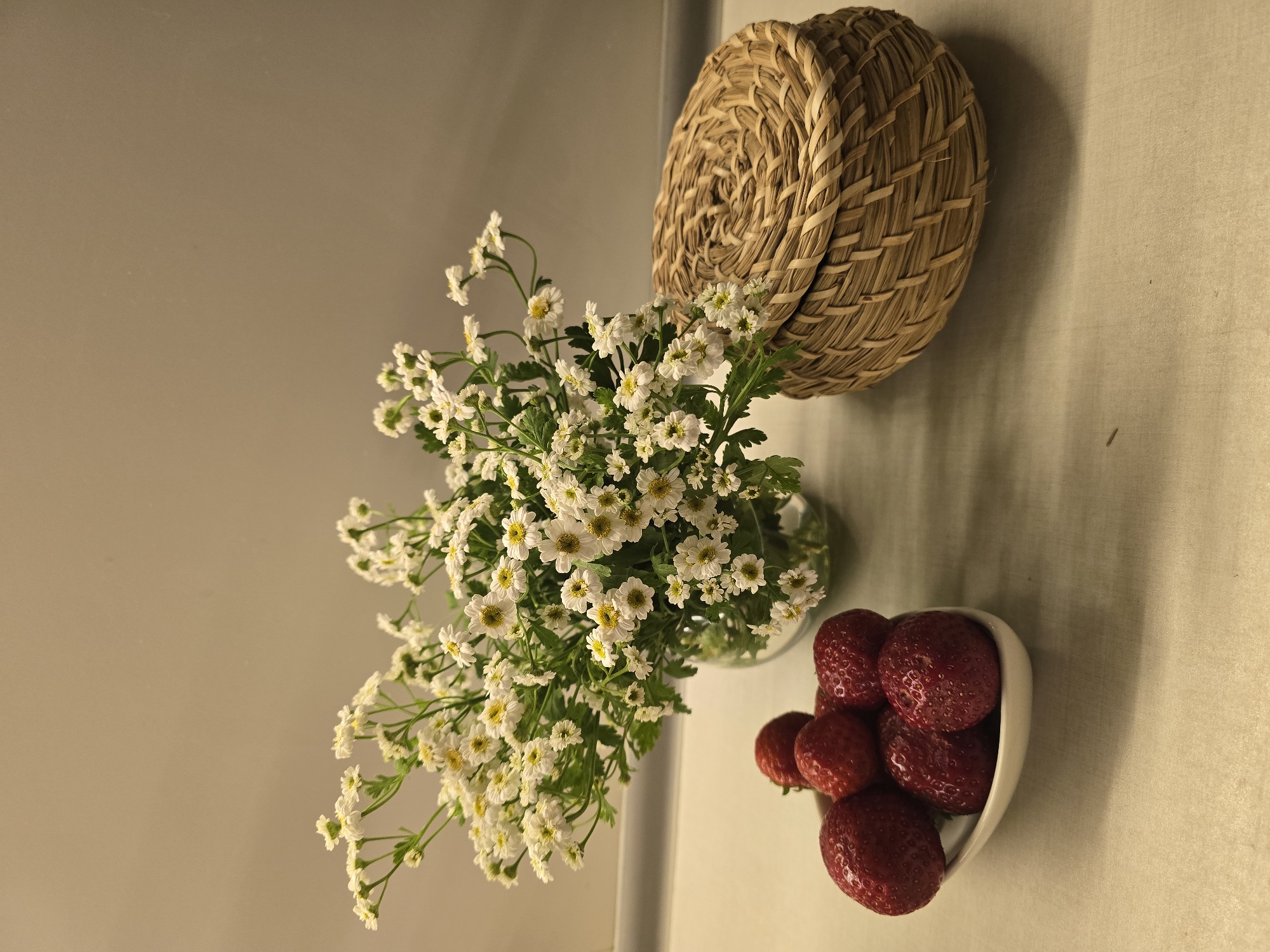 Fresh strawberries and daisies arranged on a kitchen surface