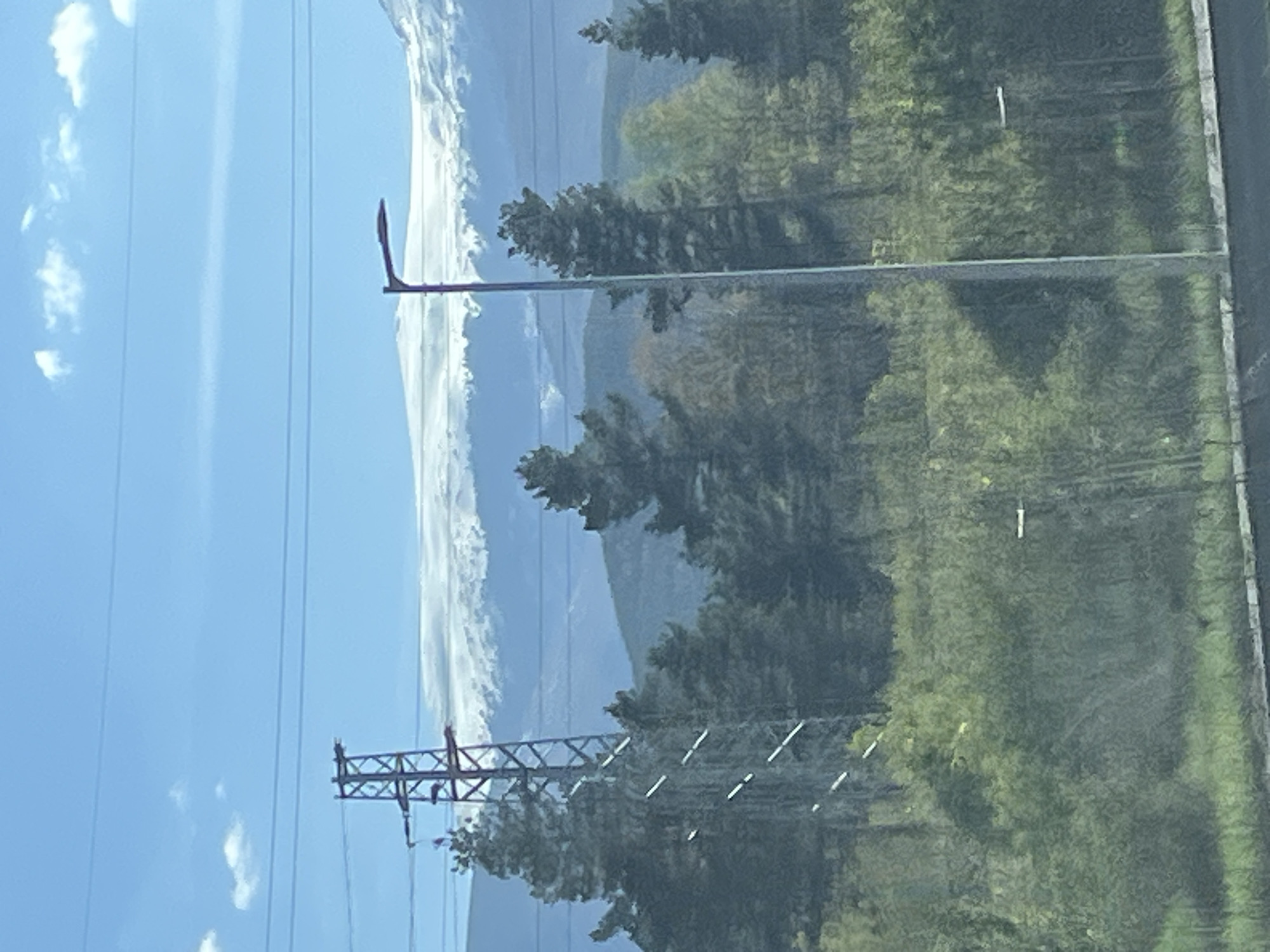 Vehicle travel through rural area with power lines, mountains