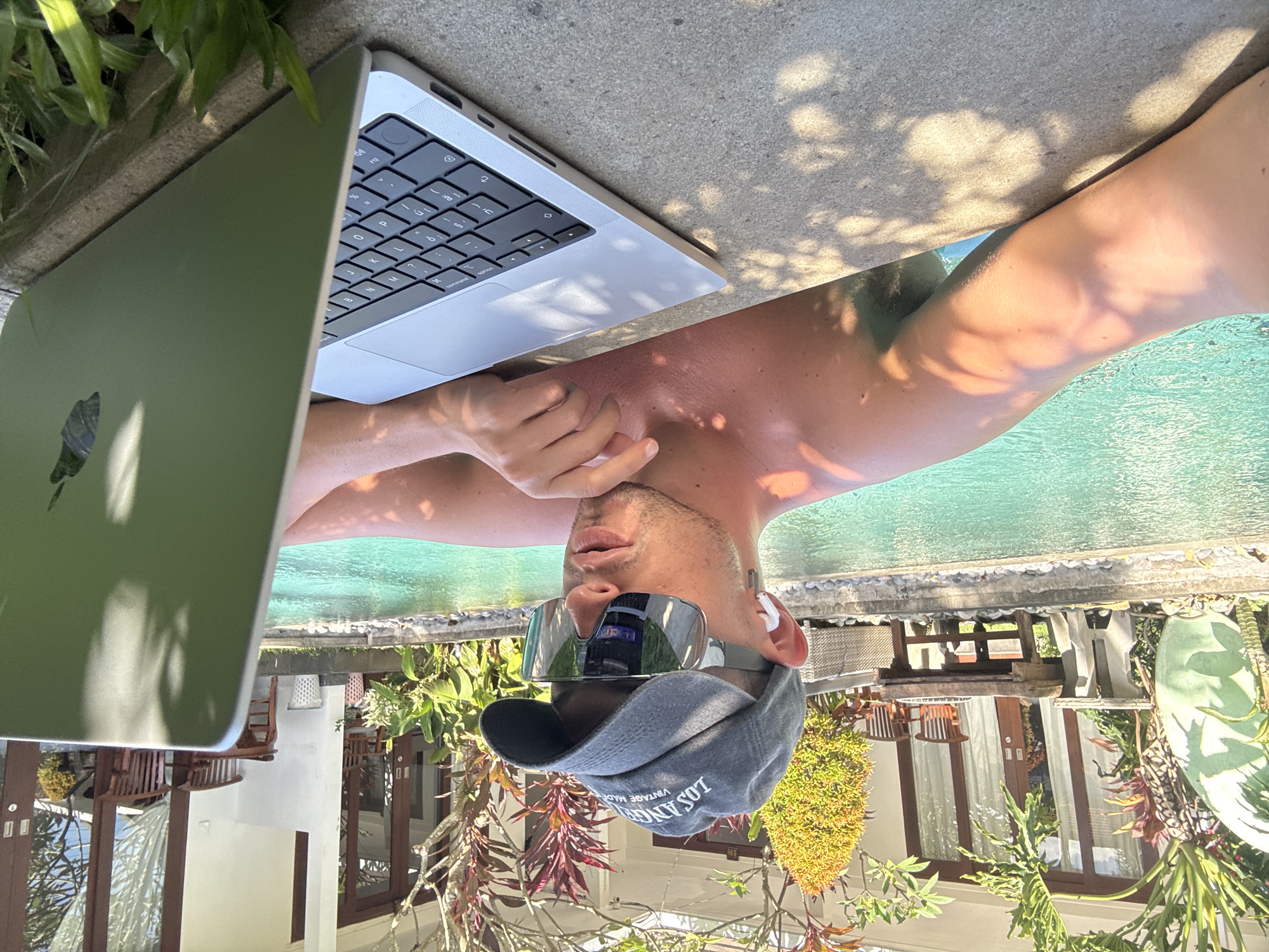 Man works on laptop poolside in North Kuta resort