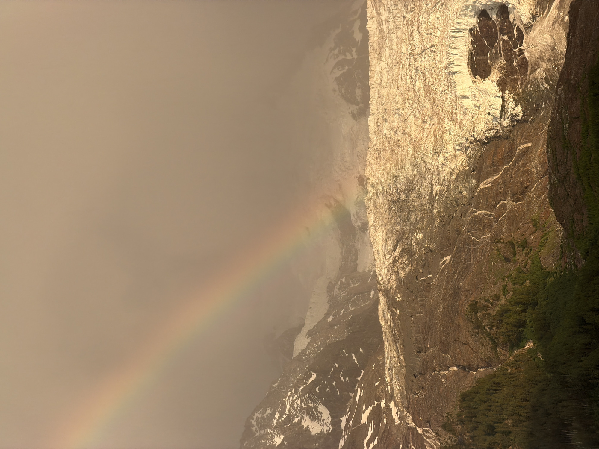 Rainbow over Mont Blanc under a hazy evening sky