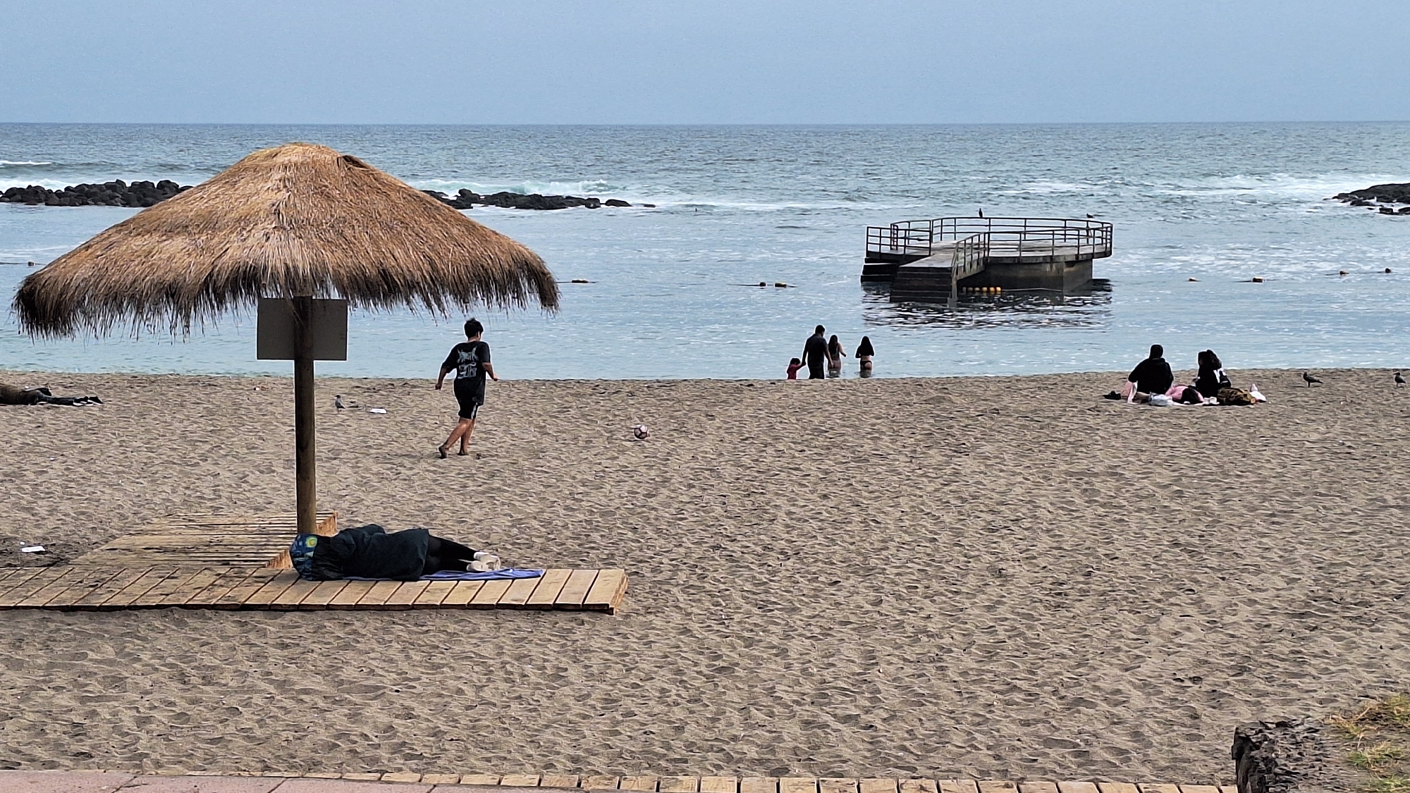 Cloudy day at Arica's beach, locals and visitors along the shore