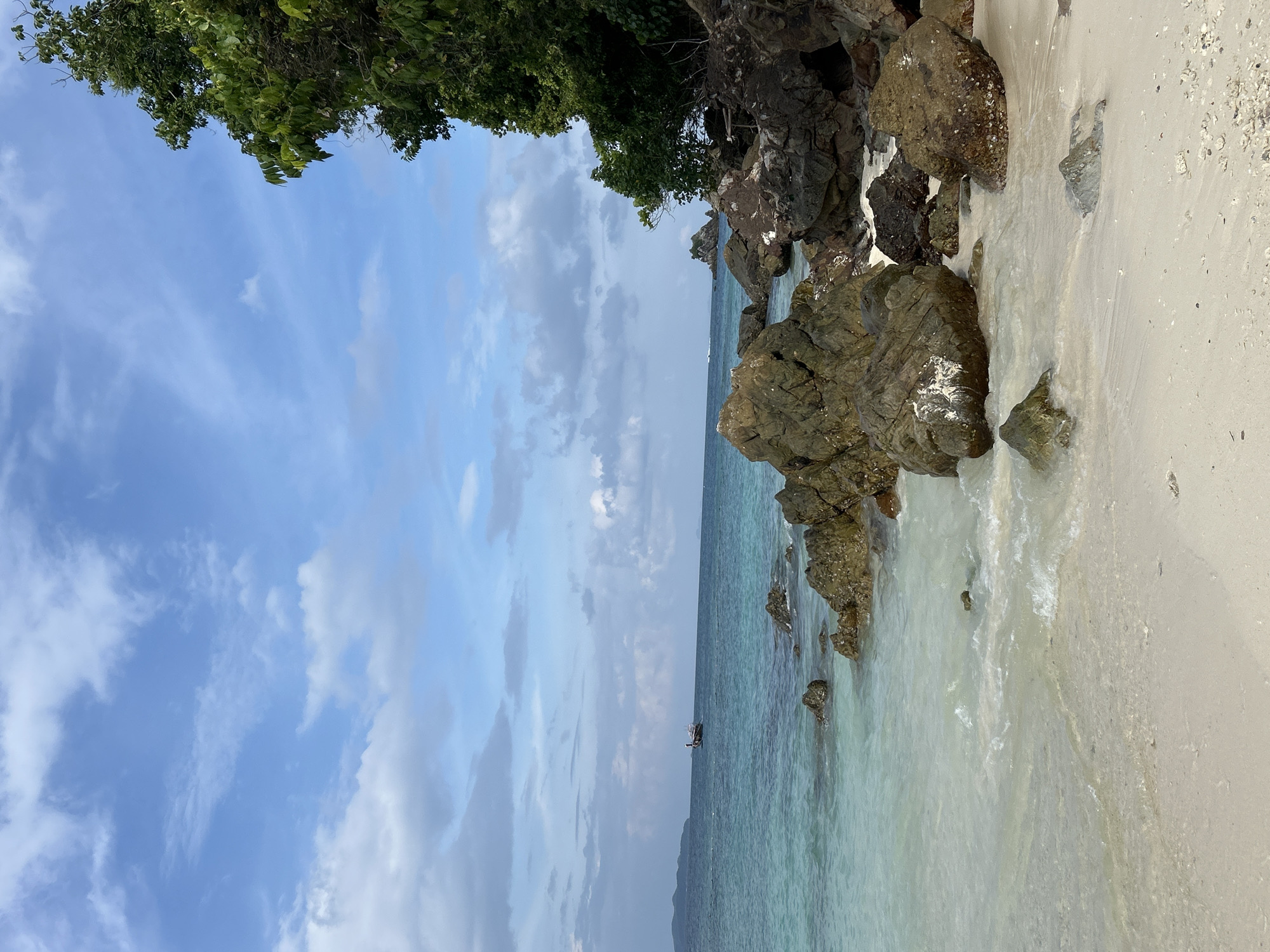 Exploring a Thai beach shore, coral in hand
