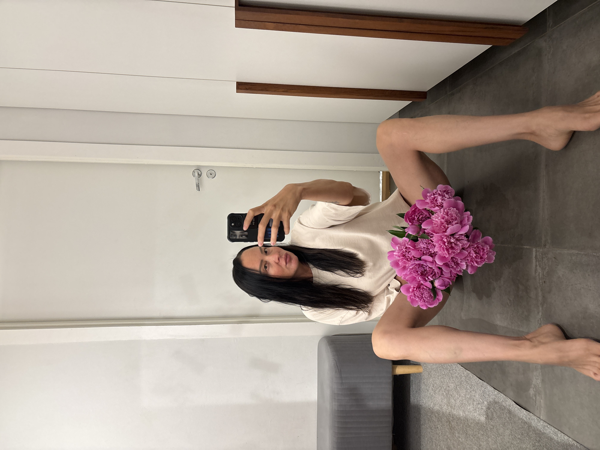 Woman documents peony bouquet gift with selfie session