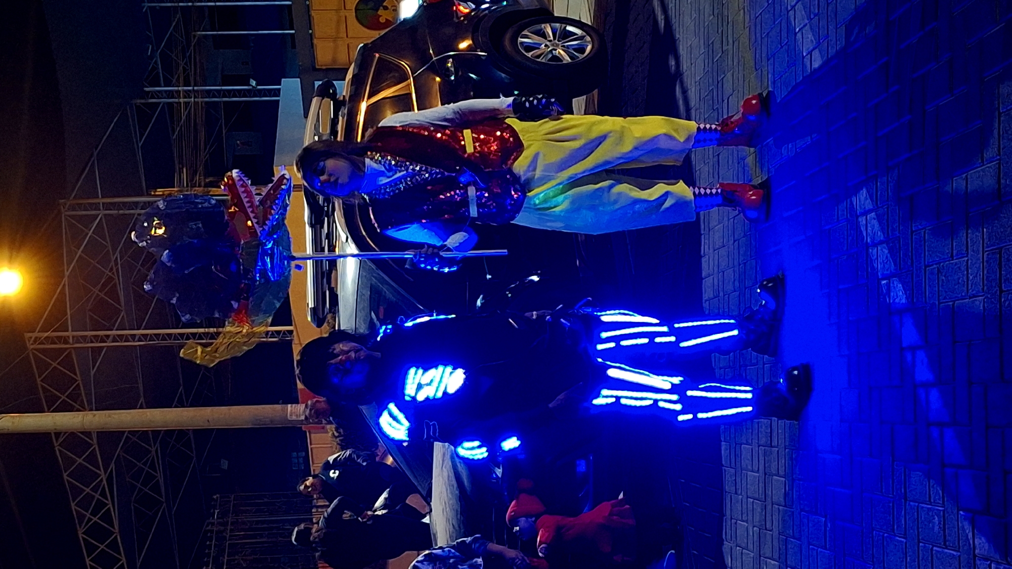 Costumed street performers entertain crowds during nighttime Miraflores celebration
