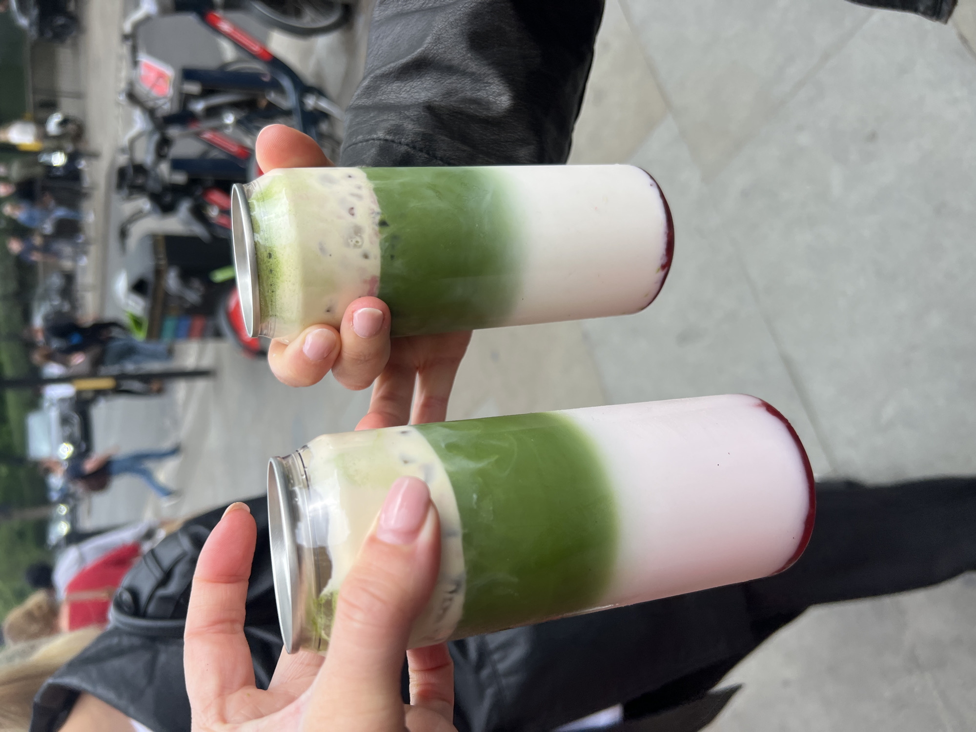 Person holds layered green drinks in London