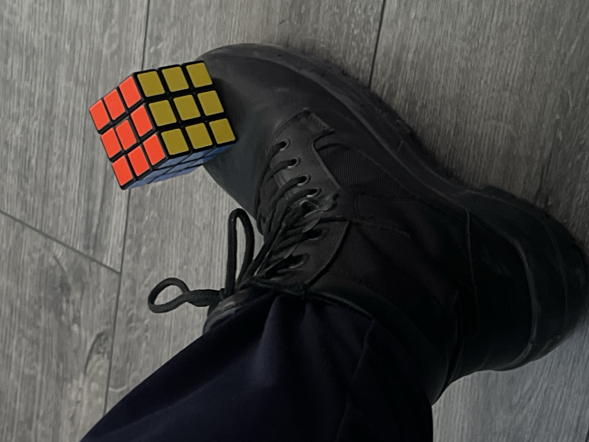 Person in uniform clothing observed with Rubik's Cube boot display